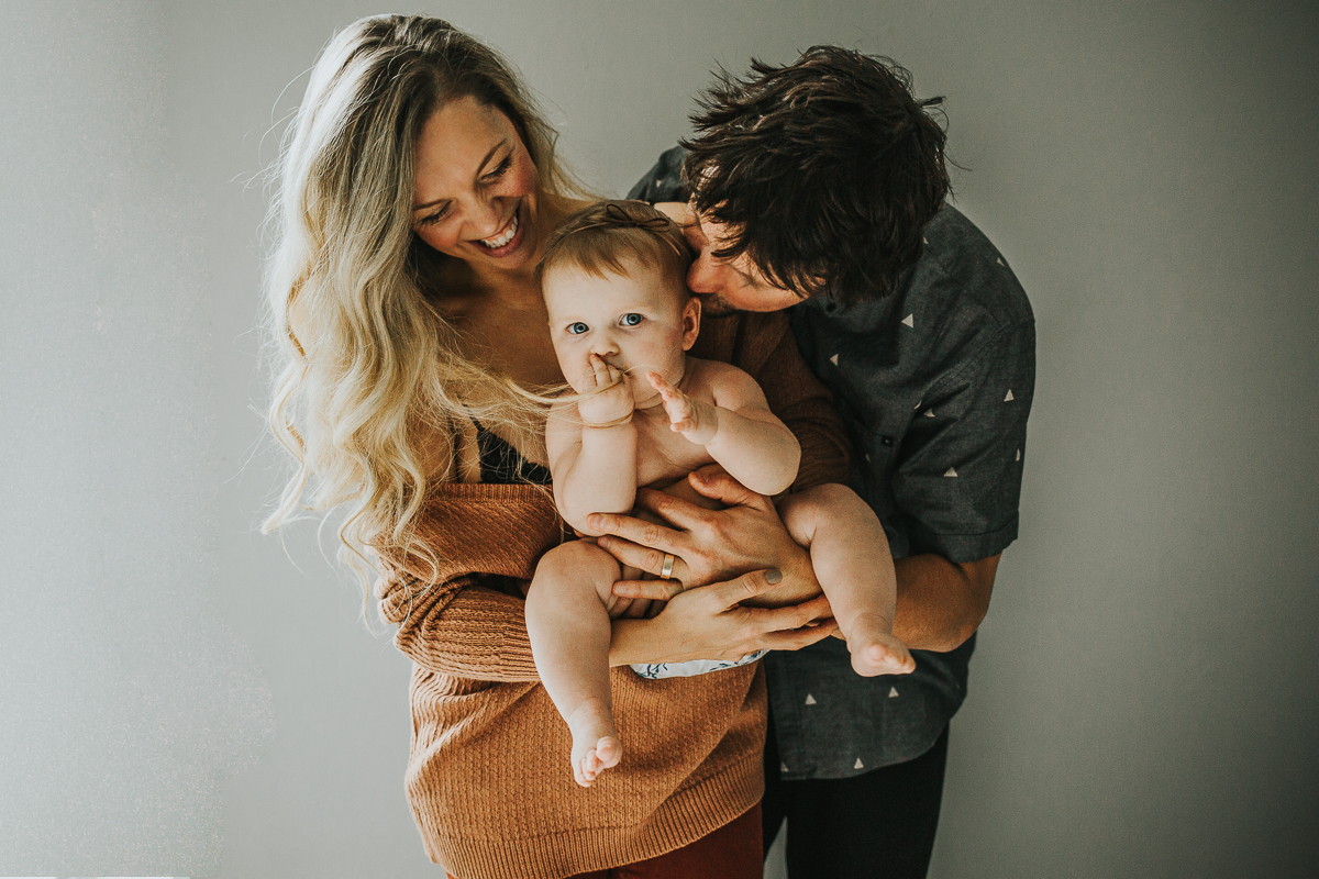 Intimate in home family session against white wall chubby baby