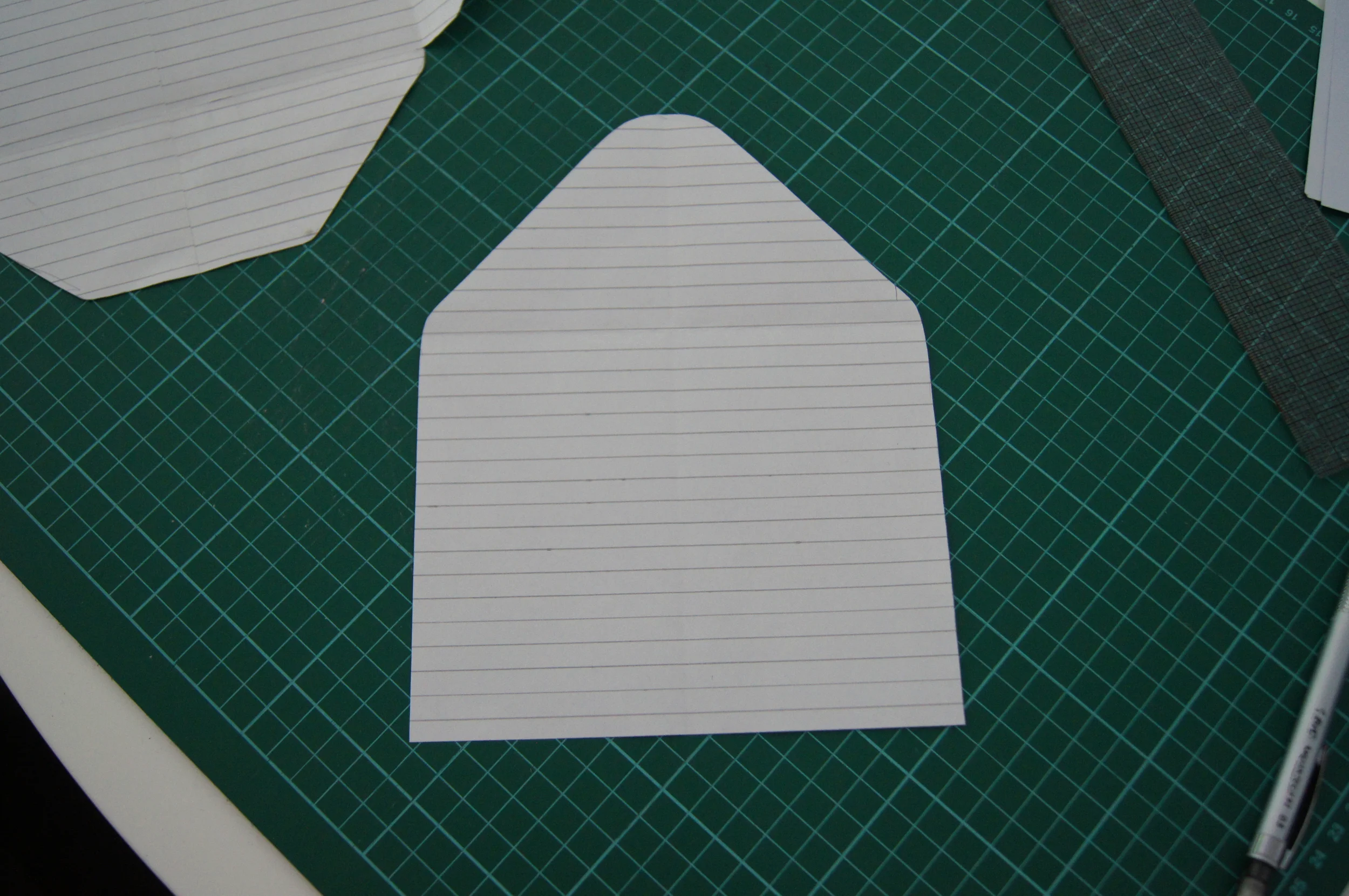 After you have made the template for the shell (navy part), you need to make one for the inside that we shall be using the gold polka dot cardstock for. To do this, I used the above finished template that we are using for the navy shell and traced around just the back section as you can see above on another piece of paper. I then made it a bit smaller so you can see a thin blue strip around the edges. The best way to do this, is to decide how thick you would like the strip and then with a ruler evenly measure around the template, cut along the new line, and then fold the template in half to make sure the sides are perfectly even; and do any trimming if needed. 