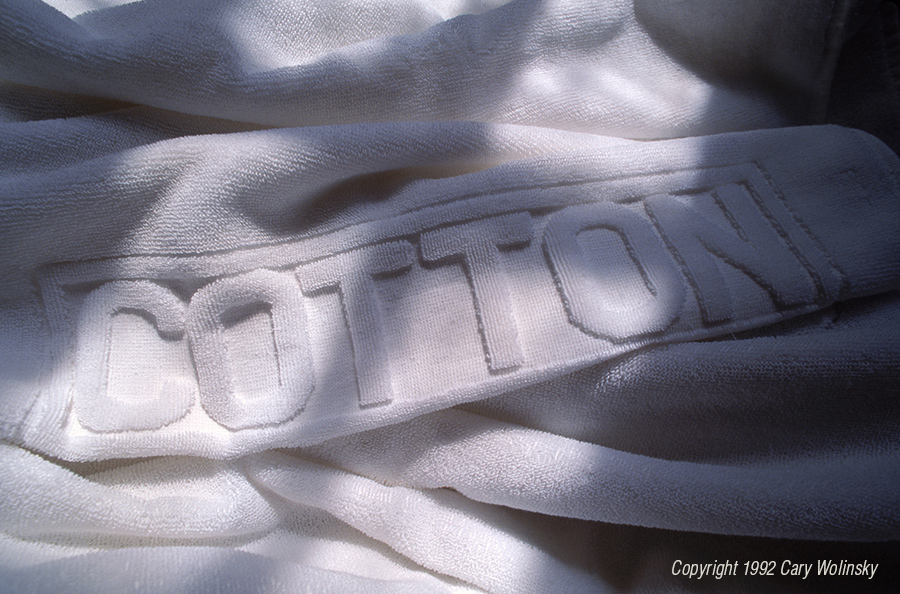 A cotton towel with the word, "COTTON" embossed in the surface. 