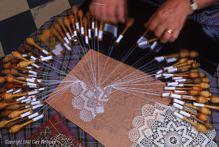 Lace making. A woman makes cotton lace using 74 bobbins in Brugge, Belgium. 