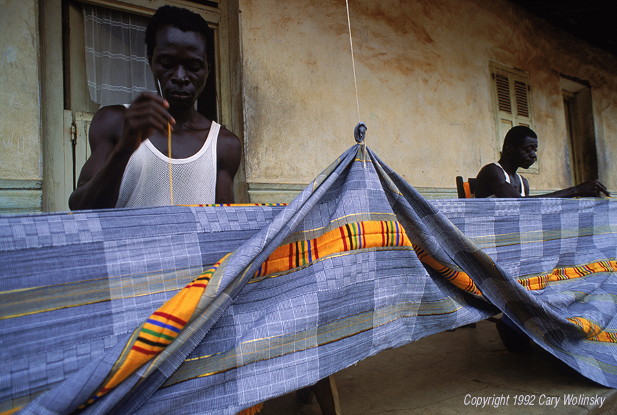 Ntonso, Ghana, West Africa. Kofi Marfo and brother Wilberforce Nyamaa sew strips of kente-style cloth with embroidery thread. 