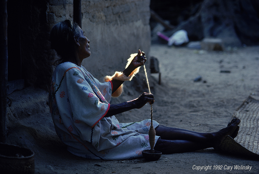 A woman spins natural brown cotton in the later afternoon sun, Zacualpan, Guerrero, Mexico 
