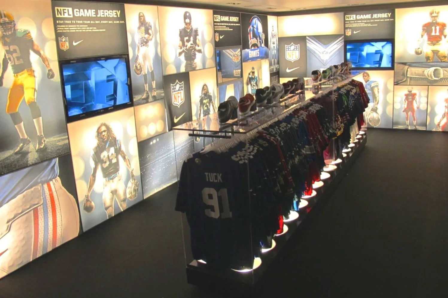  Custom in-store NFL exhibit crafted of light boxes and interactive touch-screens at the  NYC headquarters of Nike   
