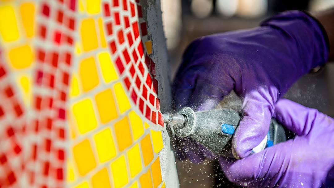  Grinding mortar to make space for the next mosaic section. Photo by Danny Fulgencio 