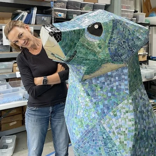 artist standing next to blue dog sculpture she created