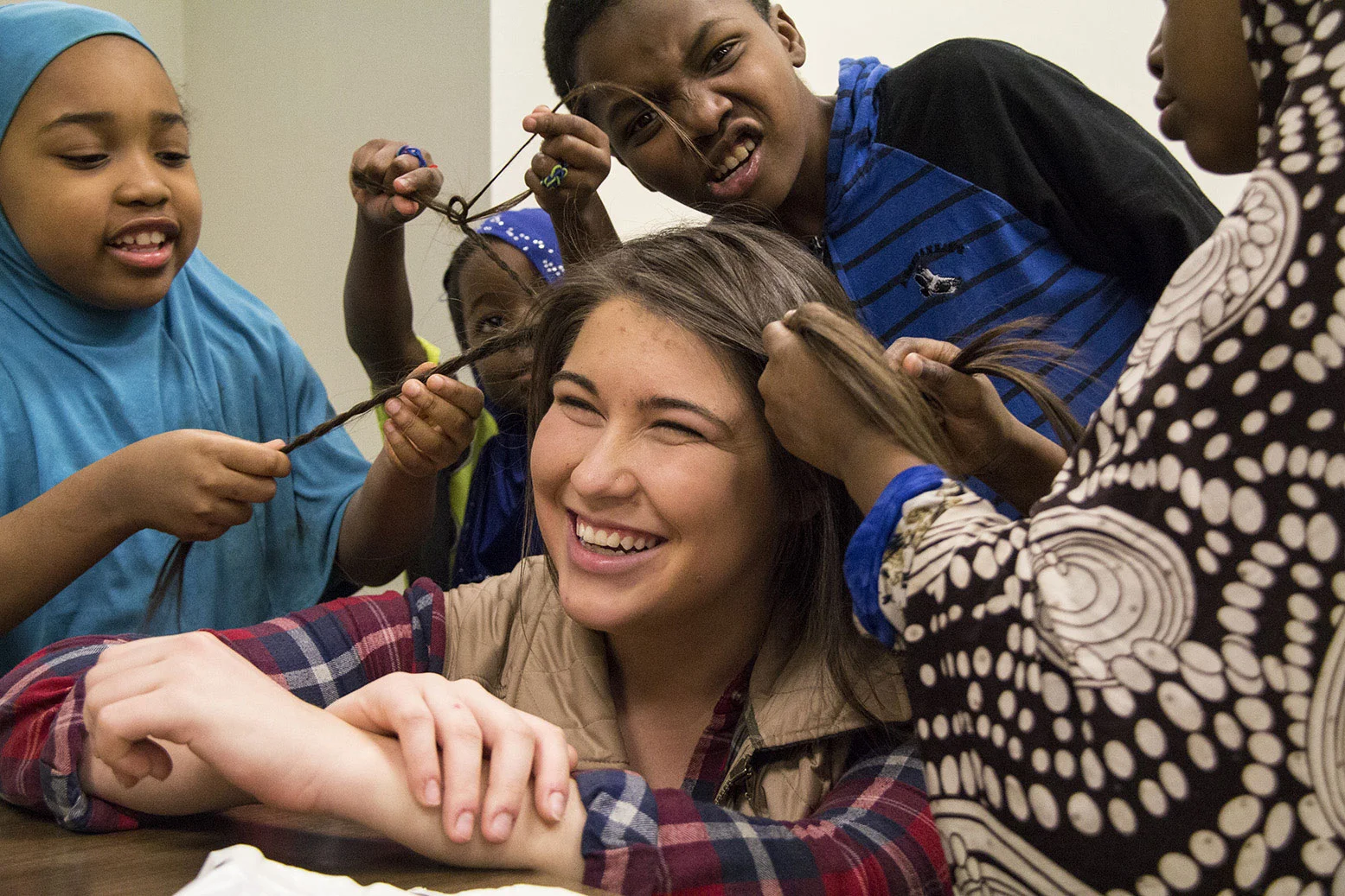 Students at the Southwest Community Center in Syracuse, N.Y., play with their tutor's hair after after finishing their homework.