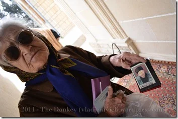 A woman from an Absheron peninsula town carries a picture of her hometown patron along with the passport of her deceased husband.