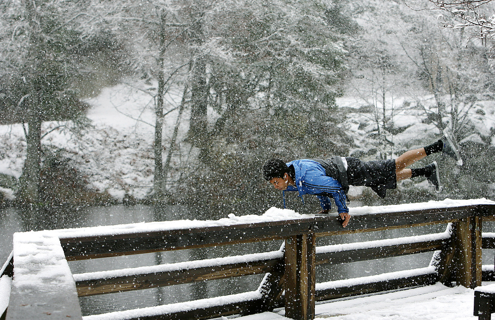  Jessy March,16, of Palm Springs shows off for friends with a hand stand on the deck of Lake Fulmor above the ice cold water as snow falls at the 5,000ft. level in the San Bernardino National Forest Sunday near Idyllwild, CA. March 1, 2015.  