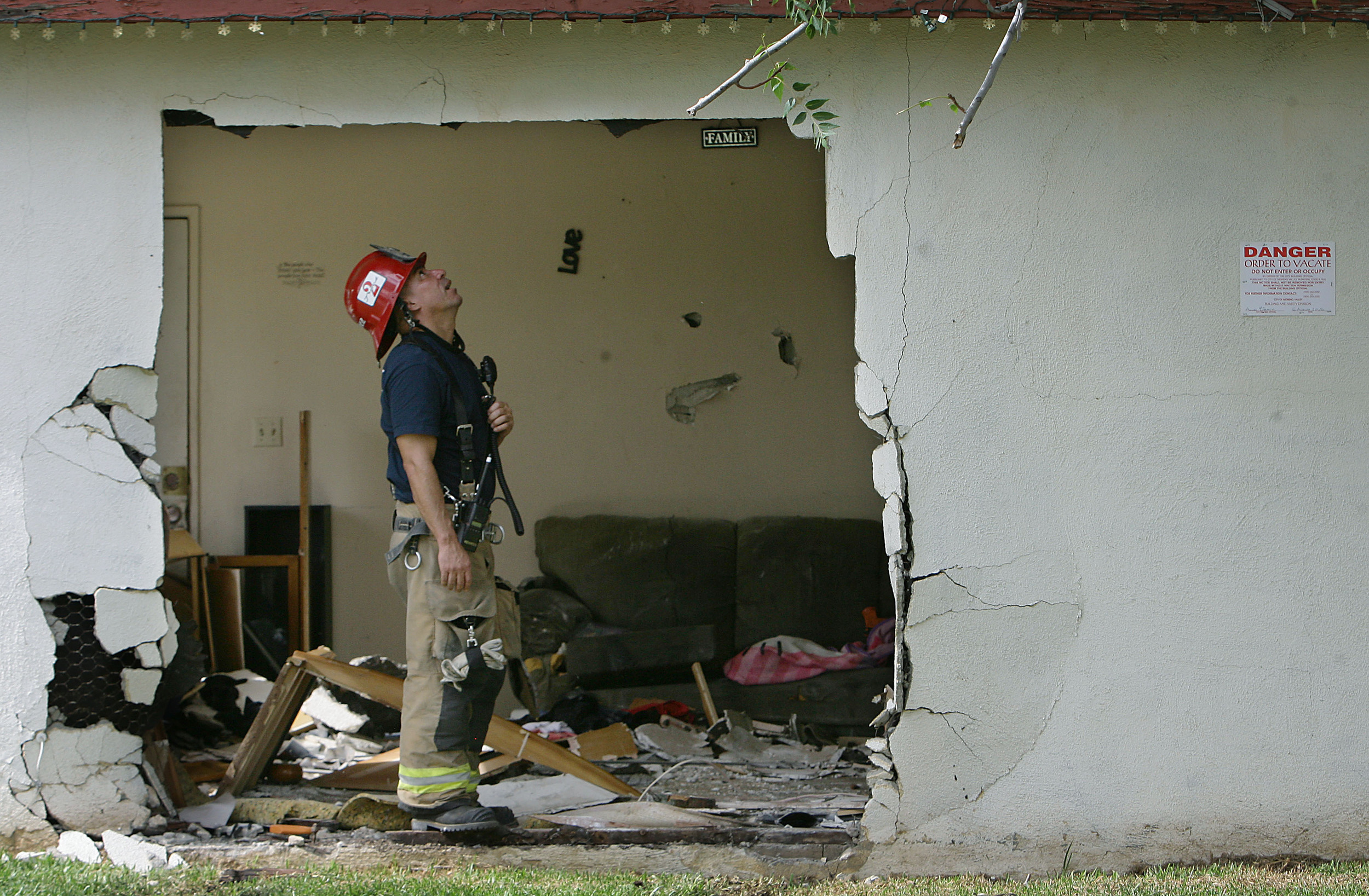  Moreno Valley Fire Station 2 fire Captain Michael Martinez looks over the damage after a pickup truck hit a parked pickup truck and plowed in to a home trapping woman between the couch and the truck Thursday in Moreno Valley, August 6, 2015. 