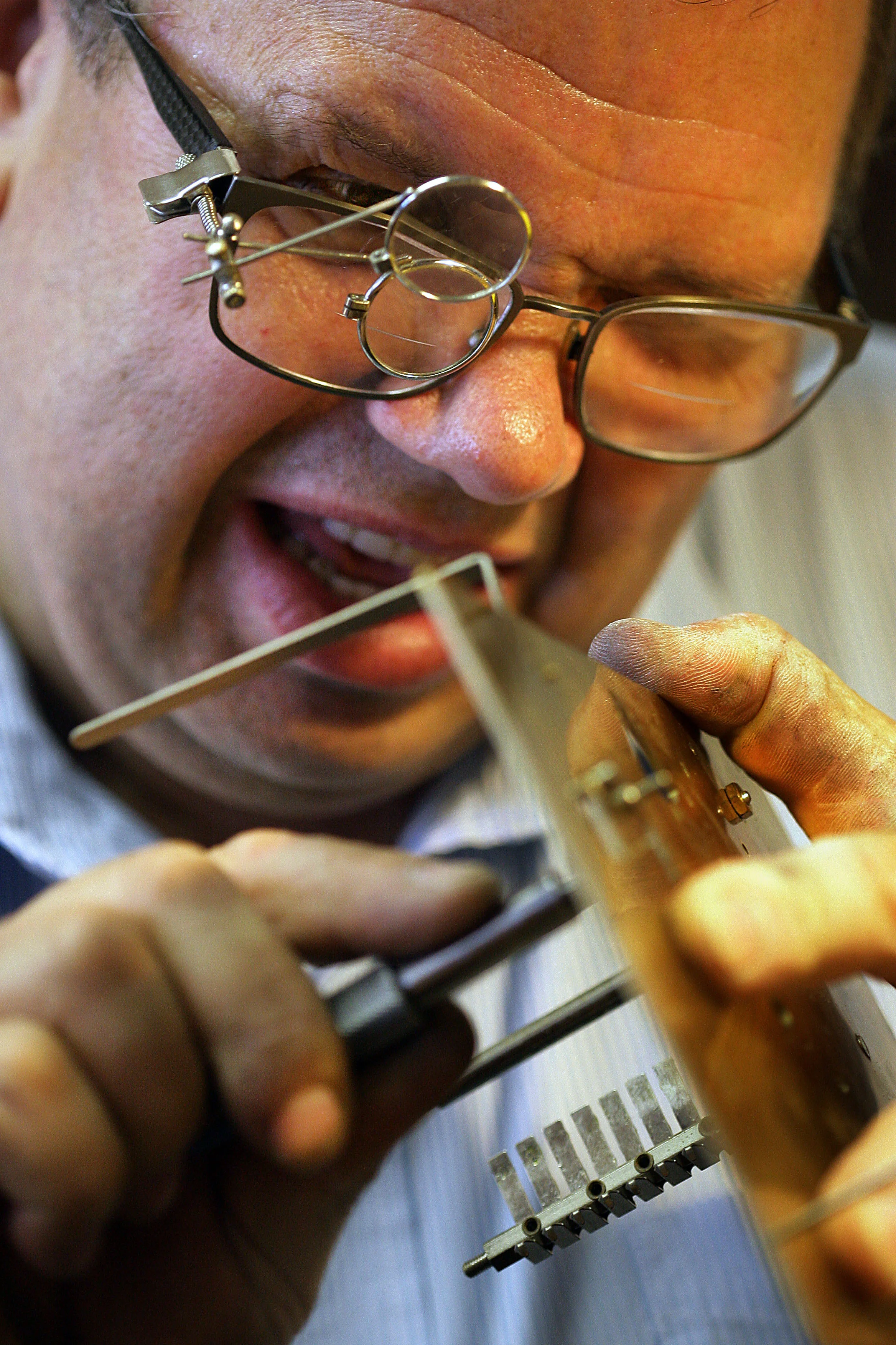 A Gift of Time owner and clock repair specialist Adrian Gheorghita, 61, uses his magnifiers attached to his glasses to rebuild a grand father clock one of many different types and styles of time pieces he repairs and sales in Loma Linda Thursday, Oct. 8, 2015.