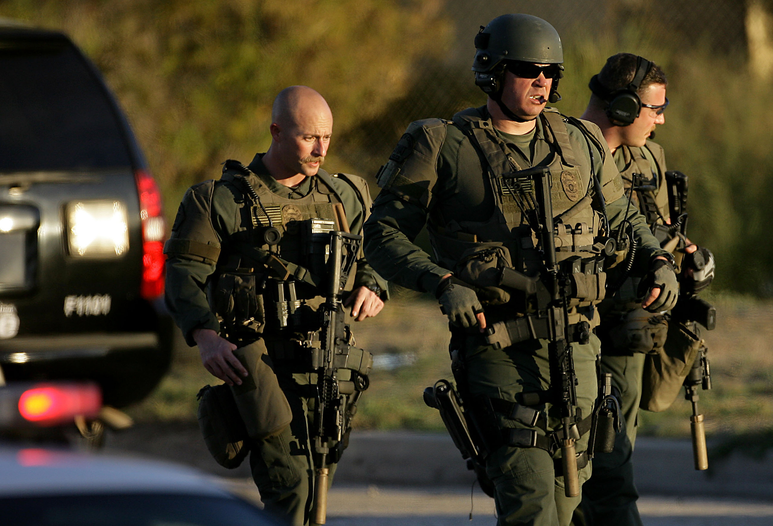  Police officers leave the scene as after one or two of the gunmen were shot and killed in a gun battle on San Bernardino Avenue east of Richardson Street after killing 14 people and shooting  14 more during a mass shooting in San Bernardino Wednesda