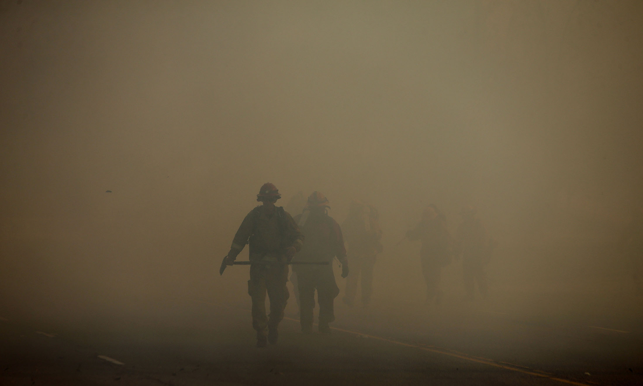 A inmate brush crew makes their way through the heavy smoke as they head to fight the Riverbottom fire Thursday in Riverside, CA. December 21, 2017. 
 