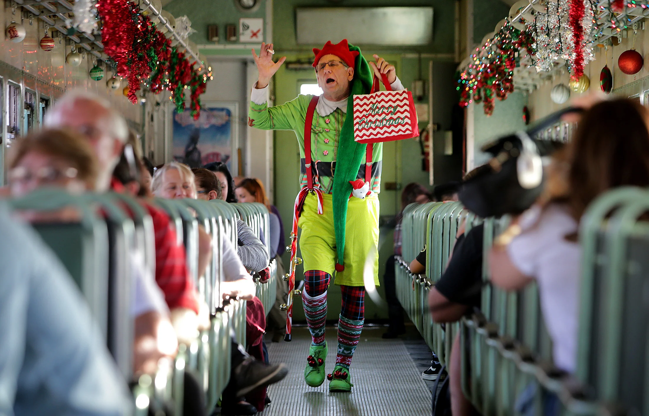 Ken Schwartz plays Jingles the elf as he sings and dances for guests on the train during "Take a Train to Santa’s Workshop" at Orange Empire Railway Museum Sunday in Perris, CA. December 3, 2017.