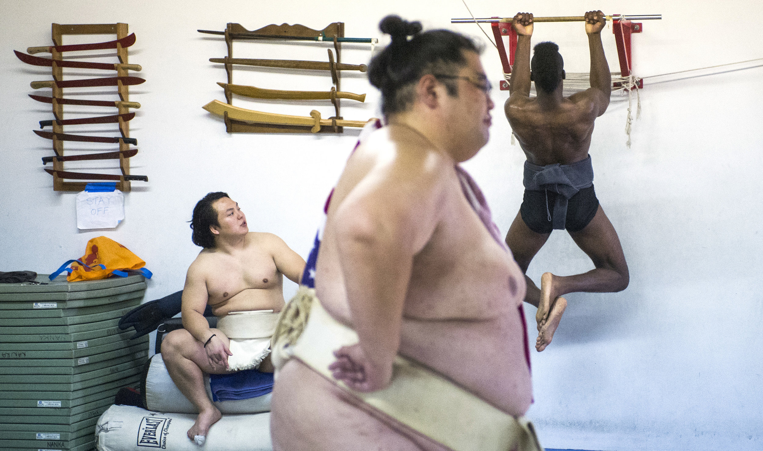  Two-time World Sumo Champion Yamamotoyama or Yama, center, watches the sumo ring as Compton native Phillip "Monster" Barnes, of Compton, do pull-ups and  Takeshi Amitani, of Japan, looks on during a sumo wrestling practice in Carson Sunday, April 8,