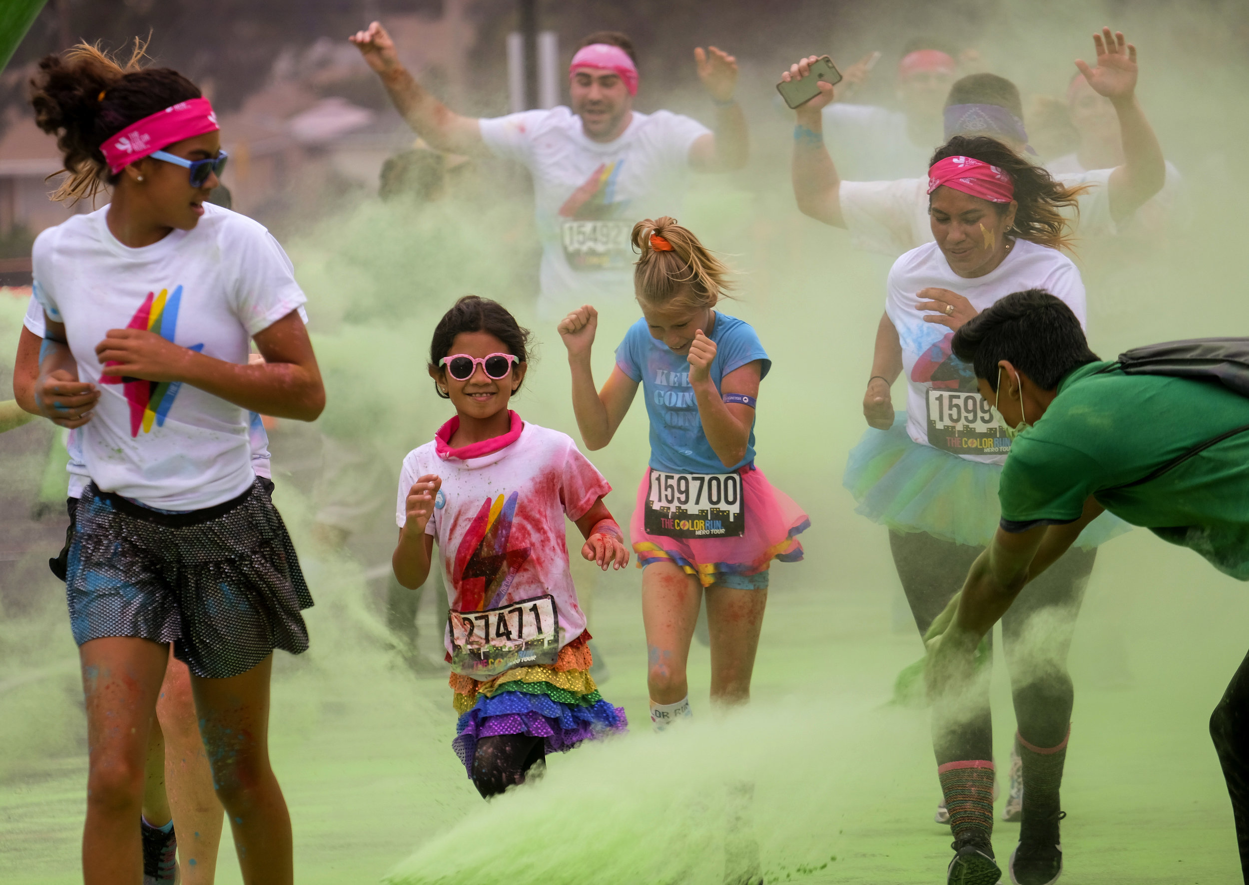  Runners revel while running through clouds of colorful powder thrown by volunteers in the Color Run at the StubHub Center in Los Angeles, United States, June 23, 2018.  