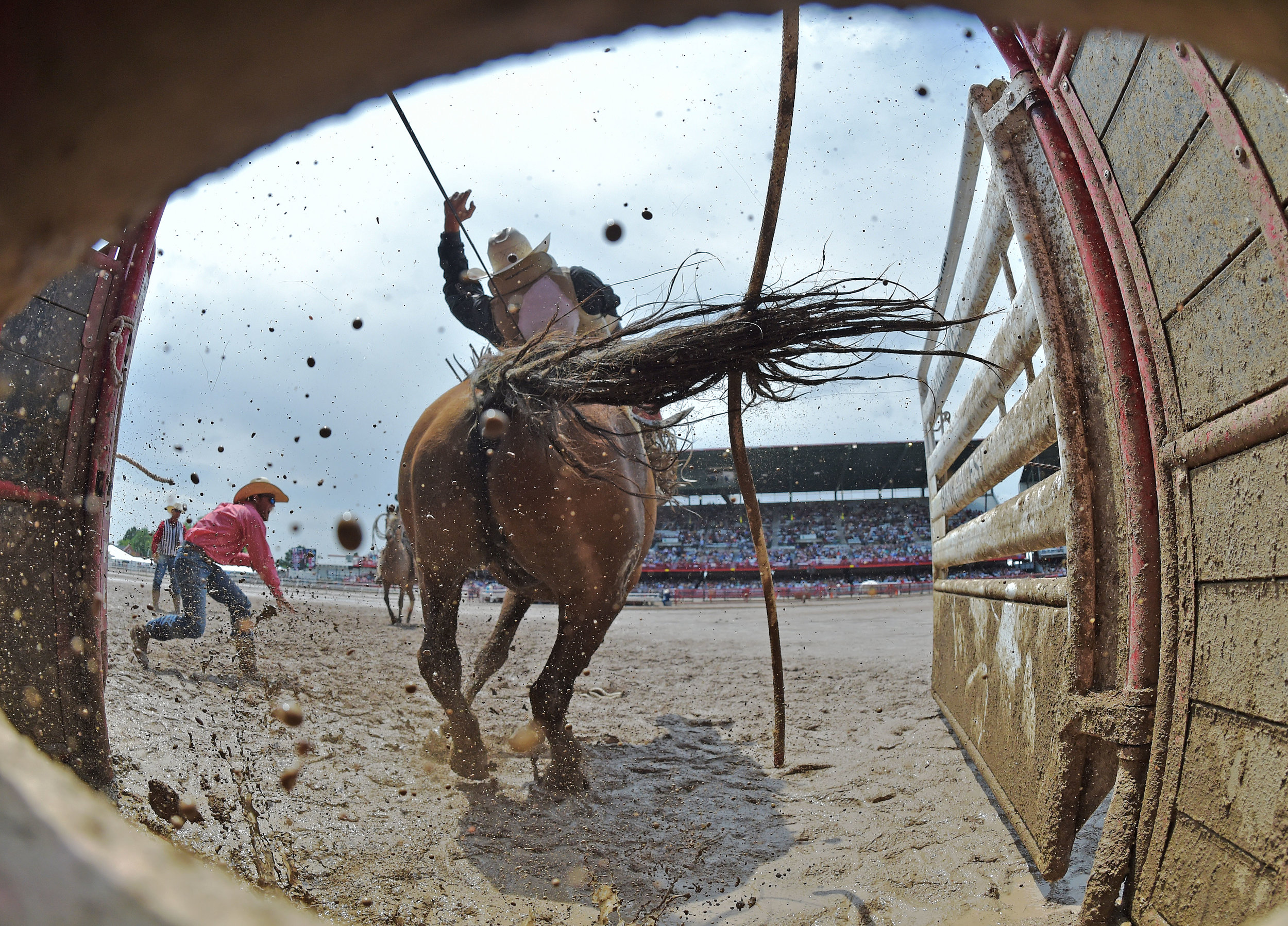  Bareback rider Ty Breuer, from Mandan, North Dakota, blast out of the chute aboard Bent Rail Sourdough during his muddy ride Saturday July 28, 2018 at the 122nd Cheyenne Frontier Days Rodeo in Cheyenne, Wyoming.  