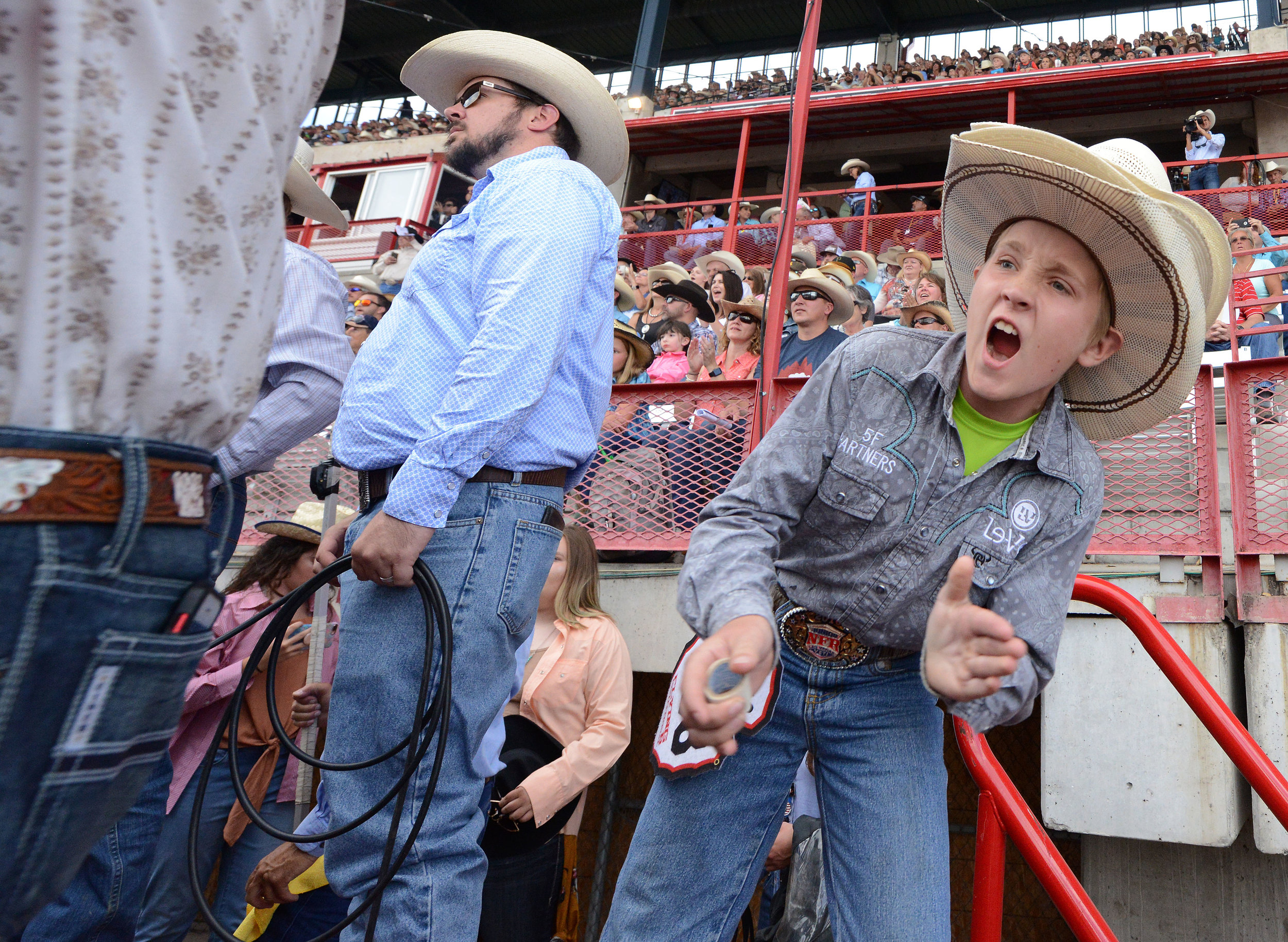  A young mini bull rider cheers on a contestant during the 6th performance at the 122nd Cheyenne Frontier Days Rodeo at Frontier Park in Cheyenne, Wyoming Wednesday, July 25, 2018.  