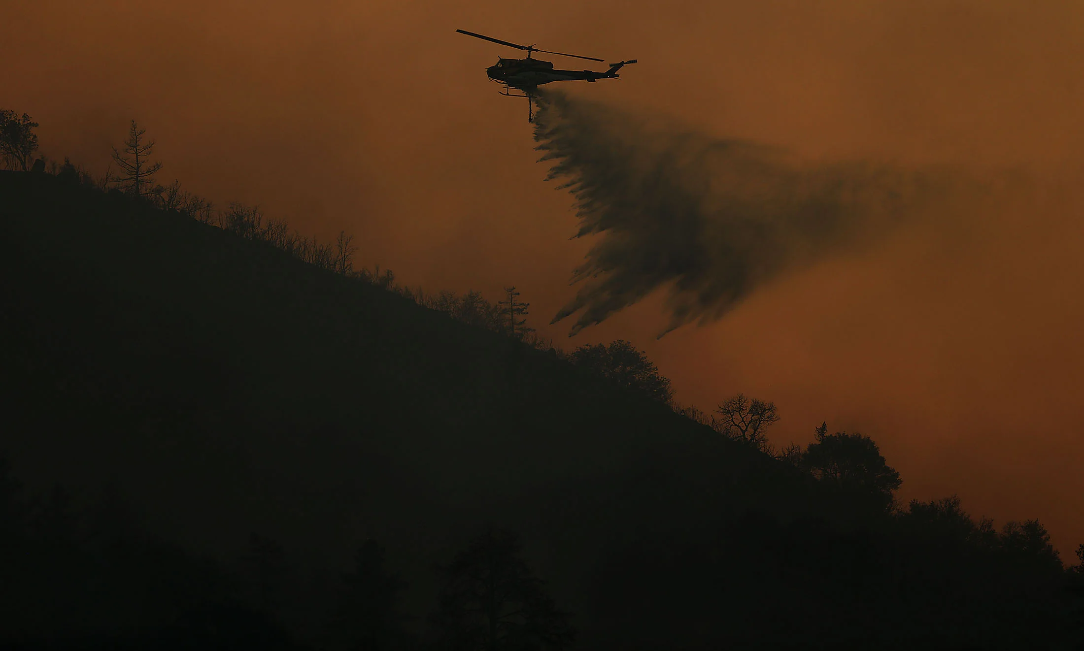 A water dropping helicopter makes a drop on the Cranston fire above Camp Keene Road along HWY 74 north of Lake Hemet in the San Bernardino National Forest in Mountain Center on Thursday, July 26, 2018.