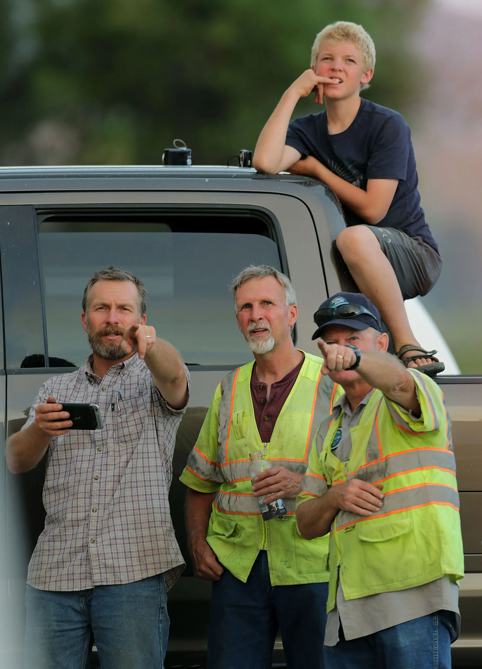 Mountain Center residents Josh Thomas, left and son Tristan Thomas, above talk others in the parking lot of the Lake Hemet Market as they watch a helicopter make a drop on the Cranston fire in the San Bernardino National Forest in Lake Hemet on Thursday, July 26, 2018.