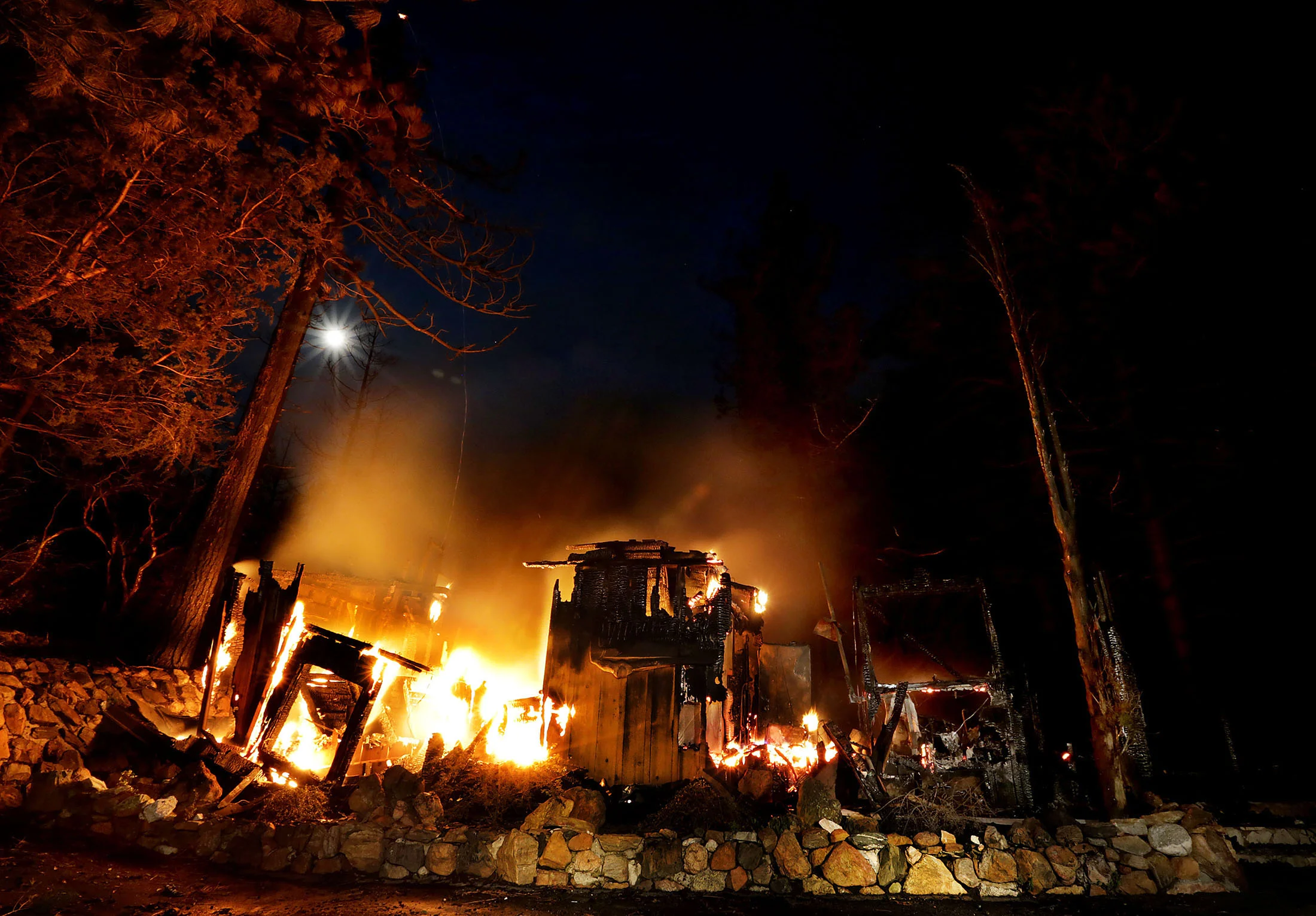A home on Deer Foot Lane burns into the night on Deer Foot Lane as the Cranston fire slows in the cool night air after during more than 3,500 acres in the San Bernardino National Forest in Idyllwild on Wednesday, July 25, 2018.