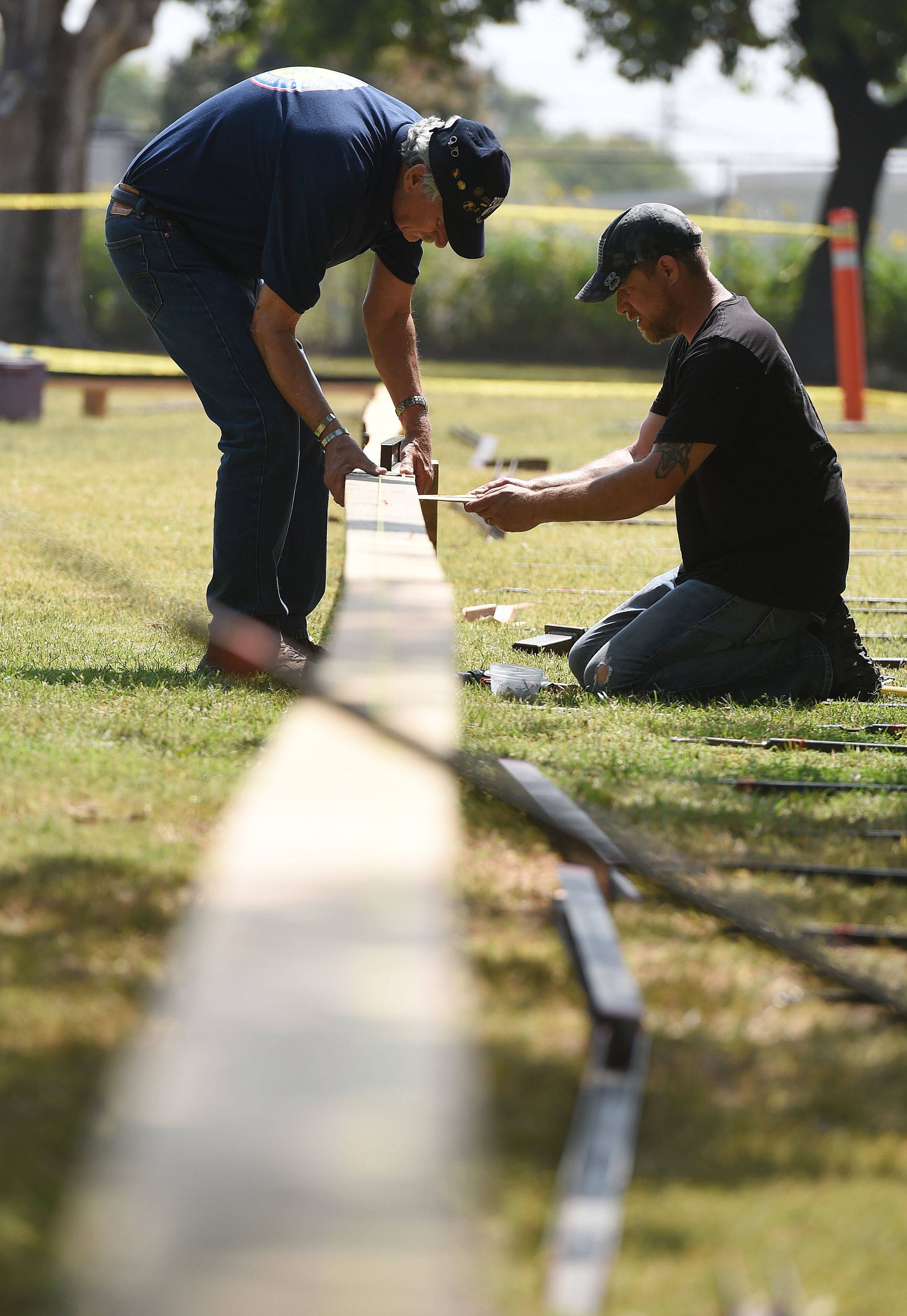  Vietnam Army veteran Steve Mackey (left), 68 from Jurupa Valley, assists Aaron Gray (right), 41 from White Pine, Michigan, as they install the base for the Vietnam Moving Wall Thursday at Ayala Park in Bloomington. Volunteers, many being Vietnam vet