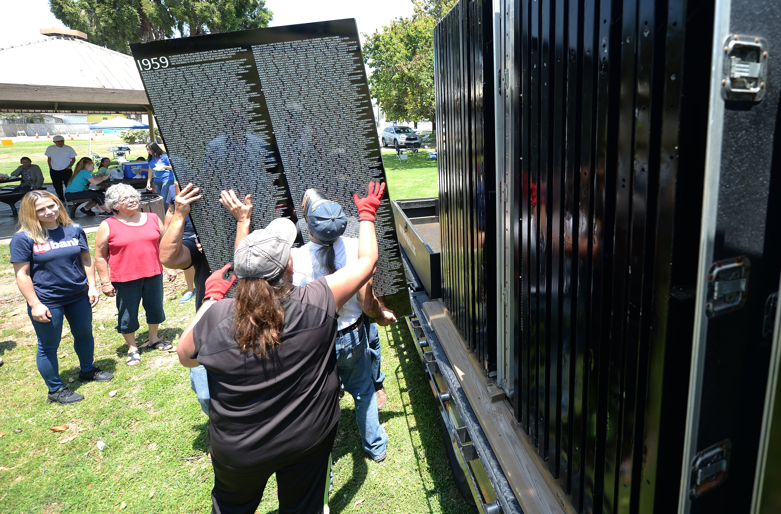  Volunteers pull the first panel of the Vietnam Moving Wall from its traveling crate Thursday at Ayala Park in Bloomington. Volunteers, many being Vietnam veterans, helped construct the Vietnam Moving Wall in Ayala Park in Bloomington Thursday June 7