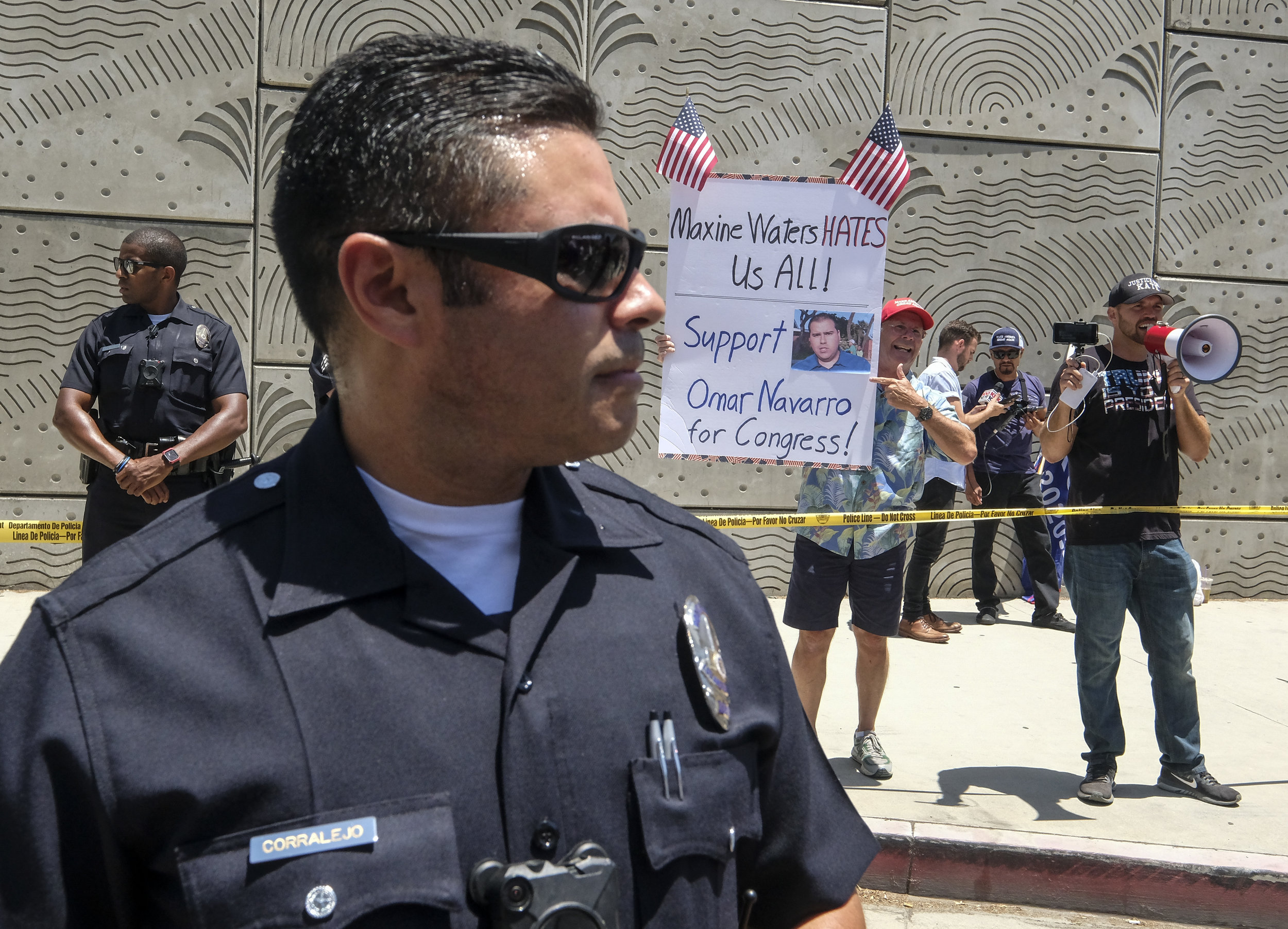  A police officer separates the Trump supporters, in the back, and the anti-Trump demonstrators during a march against the separation of immigrant families, in Los Angeles on June 30, 2018. It's one of 600-plus marches to be held across the country t