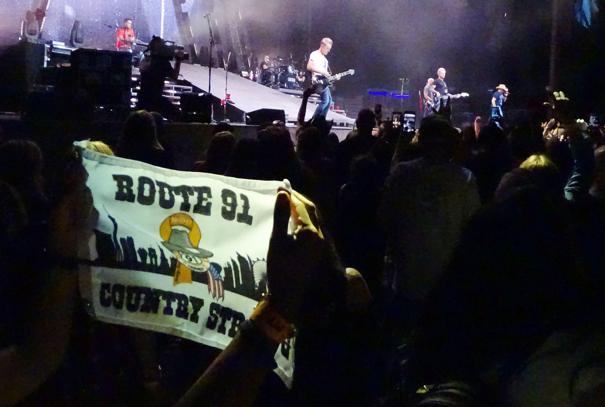  A Route 91 Harvest Festival survivor displays a small banner as Jason Aldean performs Thursday night September 20, 2018 in Chula Vista. 