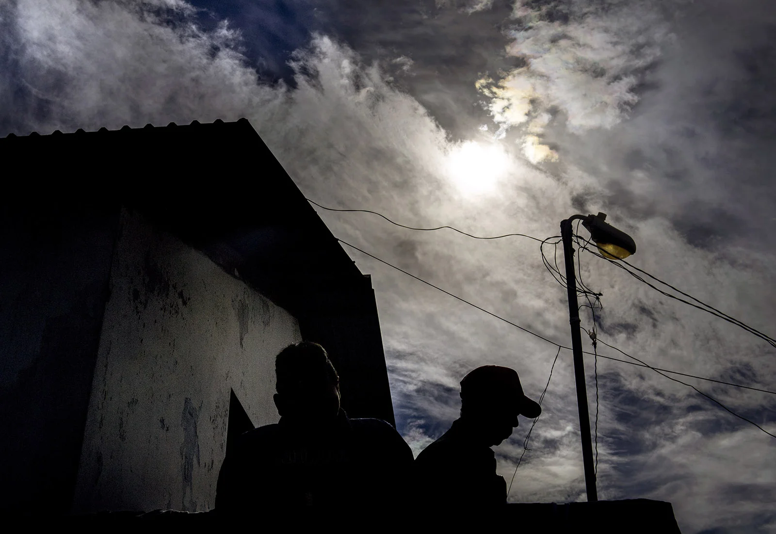 Two men while away the afternoon outside the El Barretal shelter in Tijuana on Wednesday, December 5, 2018.