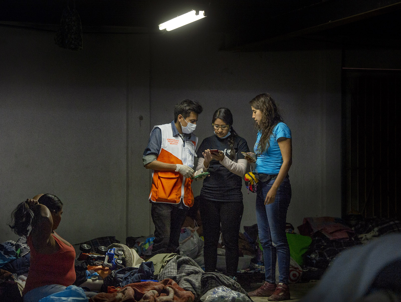 Workers with Unicef, World Vision and La Jugarreta, gather information about the welfare of children staying at the El Barretal shelter in Tijuana on Tuesday, December 4, 2018.
