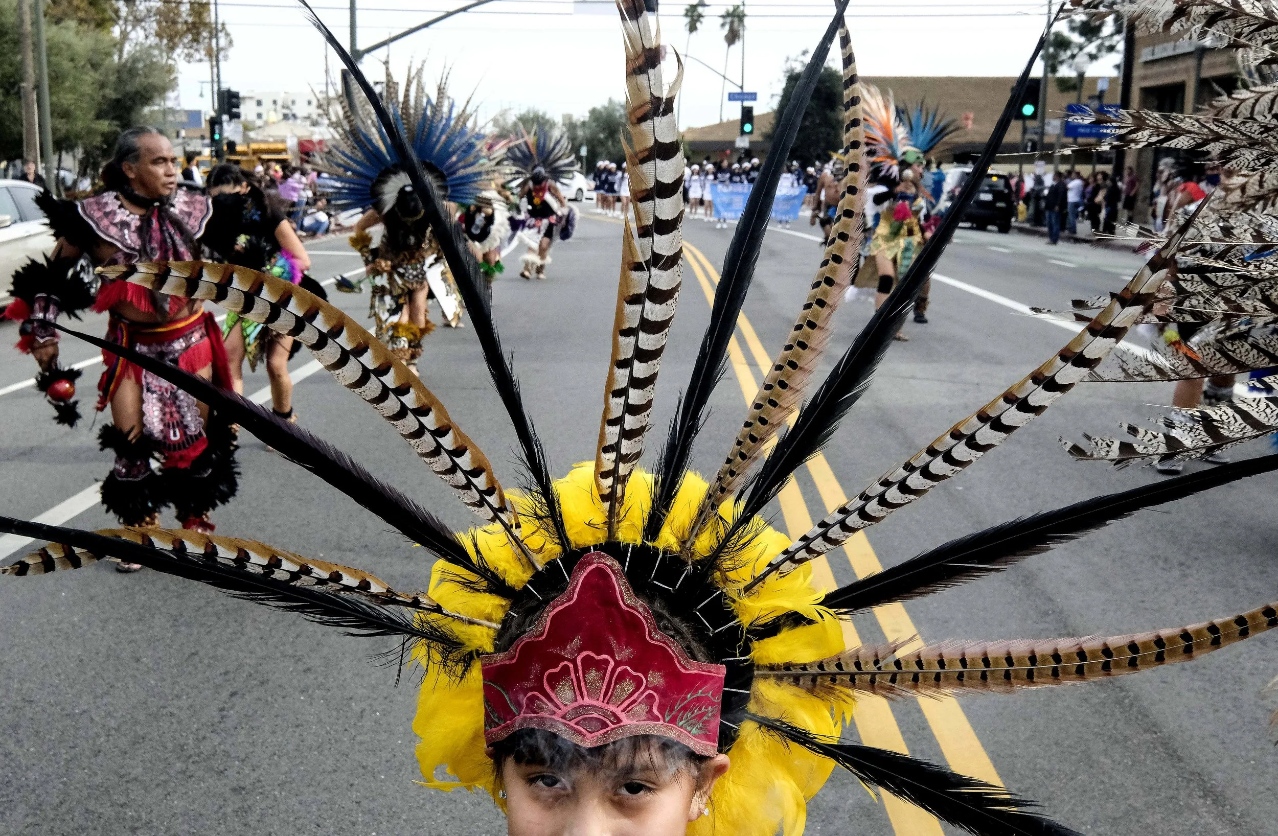  A Mexican girl, wearing a feather headgear, dances along the parade route during the annual Boyle Heights Christmas Parade in Los Angeles, the United States on Sunday December 9, 2018. 
