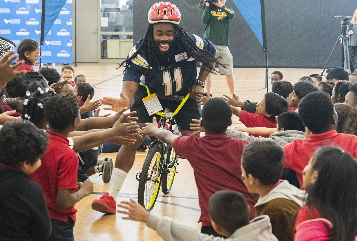  Los Angeles Charger Geremy Davis high-five students as the team donates 150 bikes to 2nd and 3rd-grade students who took part in an essay competition. The bikes were purchased by the team and California Resources Company at Cesar Chavez Elementary S