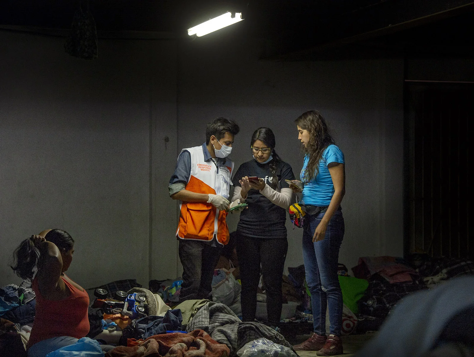 Workers with Unicef, World Vision and La Jugarreta, gather information about the welfare of children staying at the El Barretal shelter in Tijuana on Tuesday, December 4, 2018.