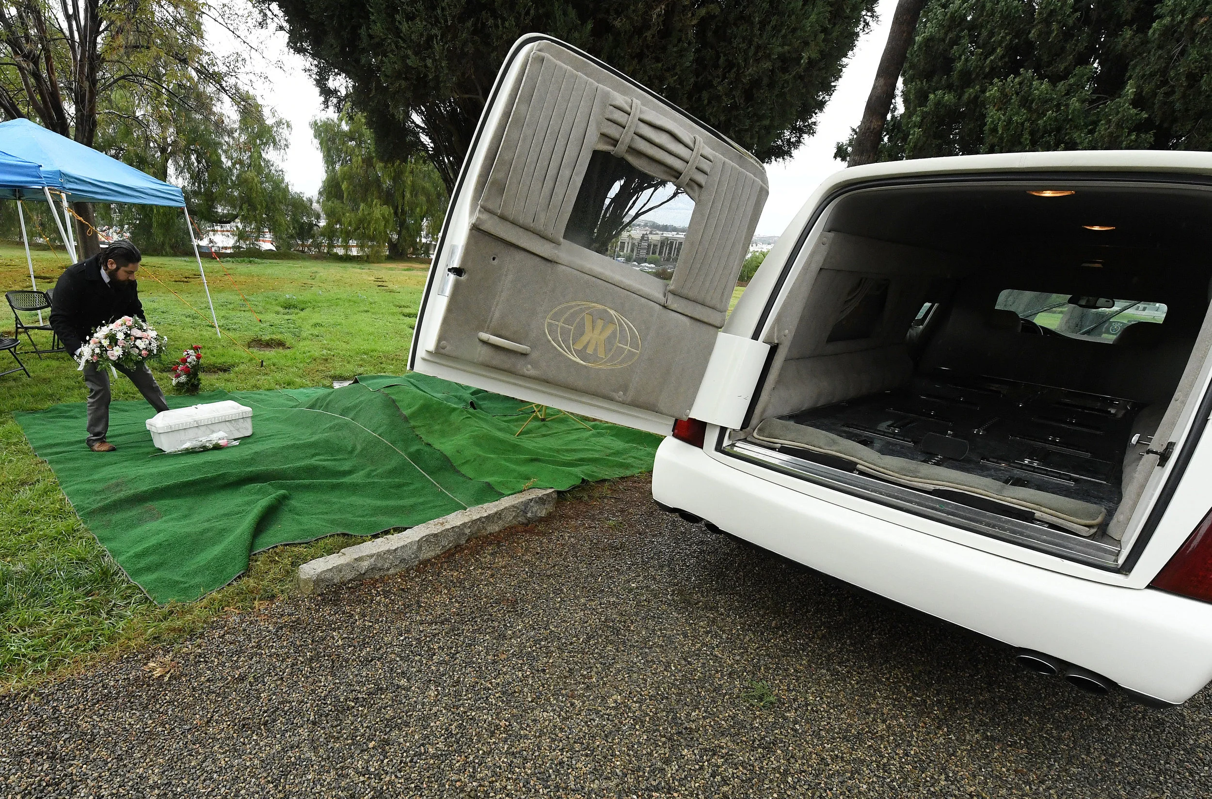  Paul Mariscal, with Thomas Miller Mortuary, places flowers atop the casket of Baby Jane Doe prior to her burial at Sunnyslope Cemetery in Corona, Thursday, December 6, 2018. The newborn infant was found in a cardboard box near the 15 freeway in Coro