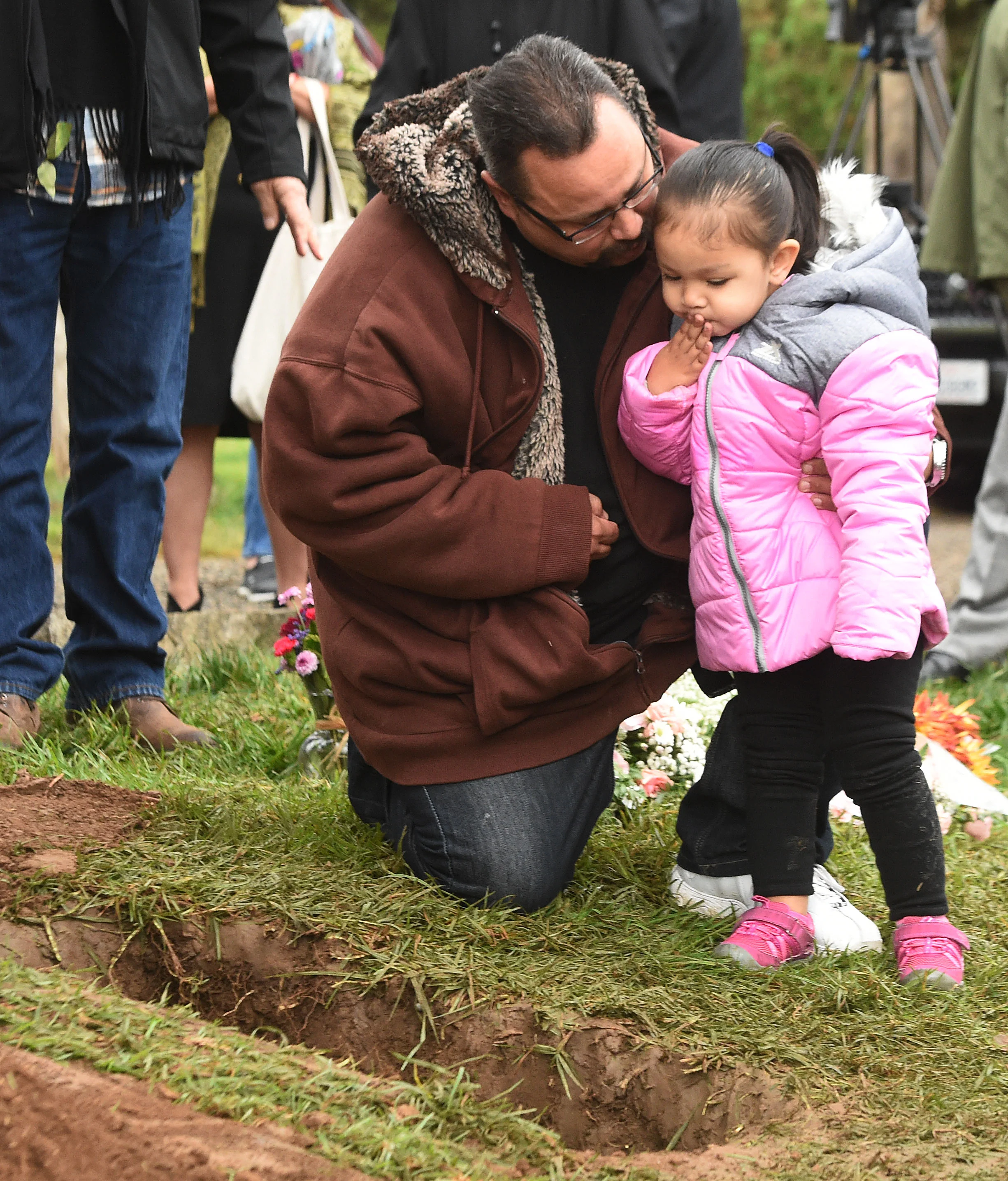  Robert West supports his daughter Sophia, 2, as she blows a kiss towards the small casket containing the remains of Baby Jane Doe at Sunnyslope Cemetery in Corona, Thursday, December 6, 2018, West's infant son is buried only feet away. The newborn i