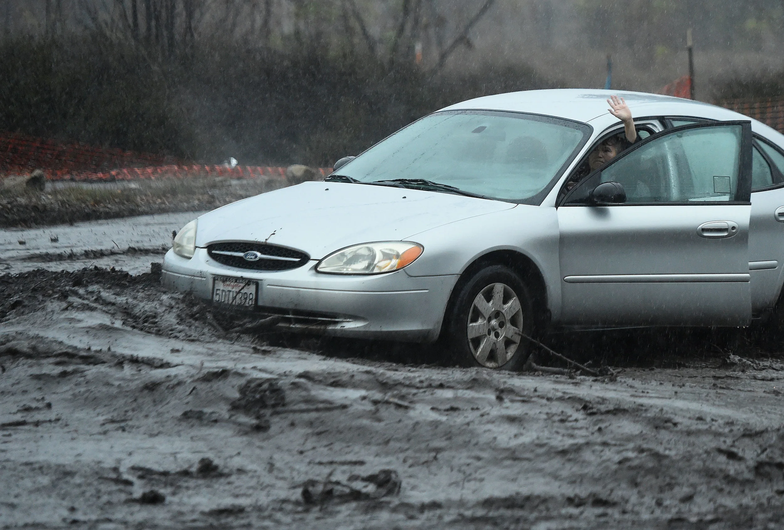  A motorist becomes stranded after trying to drive through flood waters as they crossed Temescal Canyon Road near Glen Ivy Road in Corona, Thursday, December 6, 2018.  