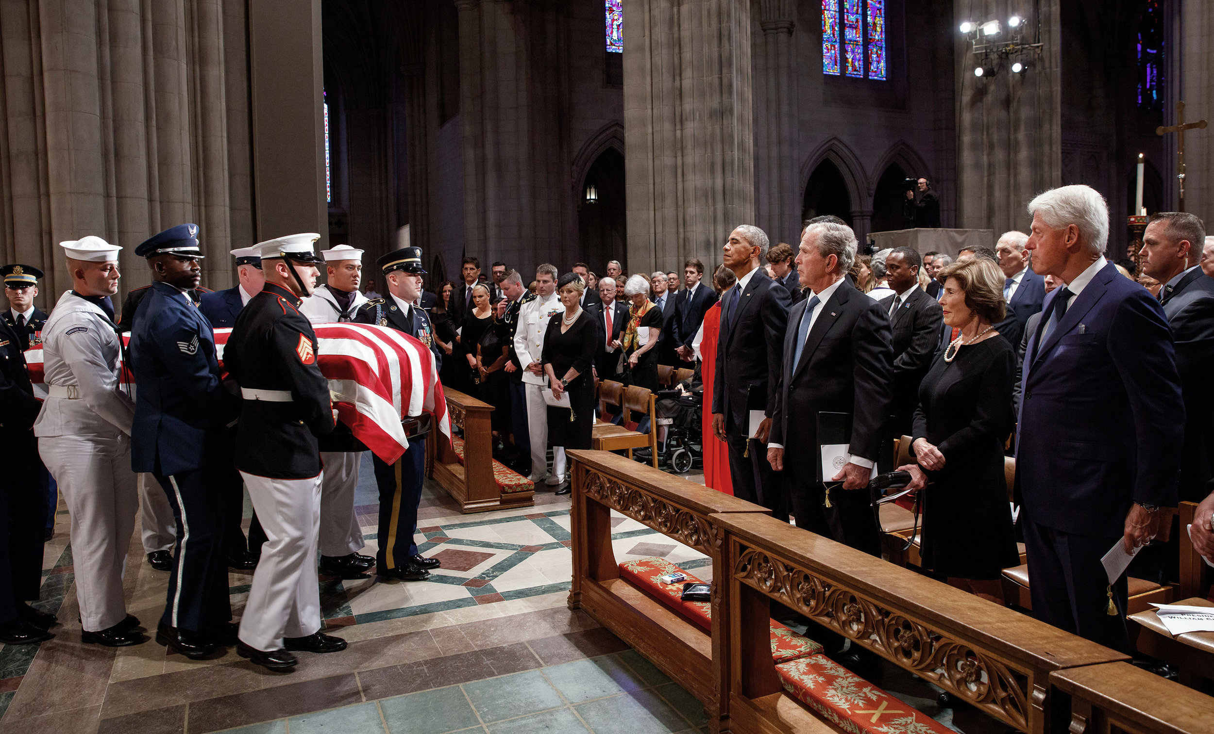  Former presidents Barack Obama, George W. Bush, and Bill Clinton watch the casket of Sen. John McCain  leave the National Cathedral in Washington, D.C. The McCain family is gathered on the other side of the aisle.  Obama and Bush, who both ran again