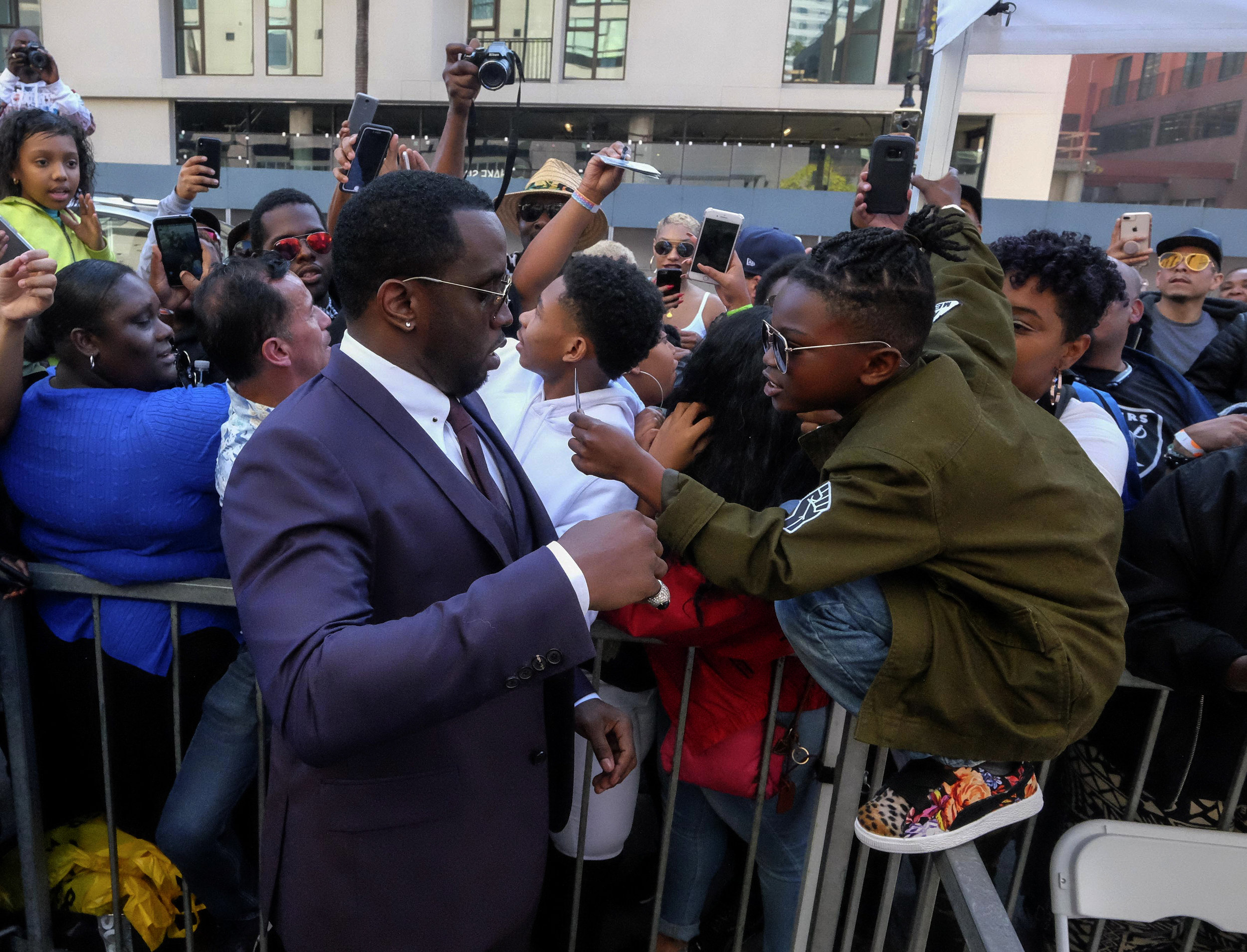  A young fan asks Sean 'Diddy' Combs for an autograph as he attends the ceremony honoring Mary J. Blige with a Star on The Hollywood Walk of Fame held on January 11, 2018 in Hollywood, California. 