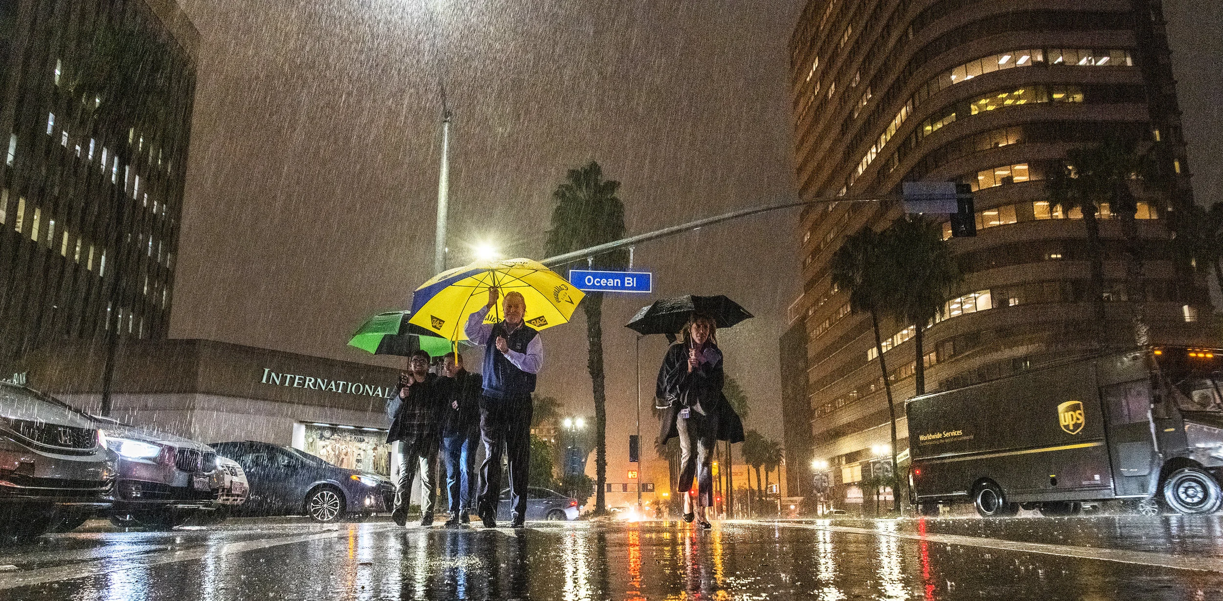  A group crosses Ocean Boulevard as they take cover under umbrellas as the rain comes down during a recent storm In Long Beach January 15, 2019. 