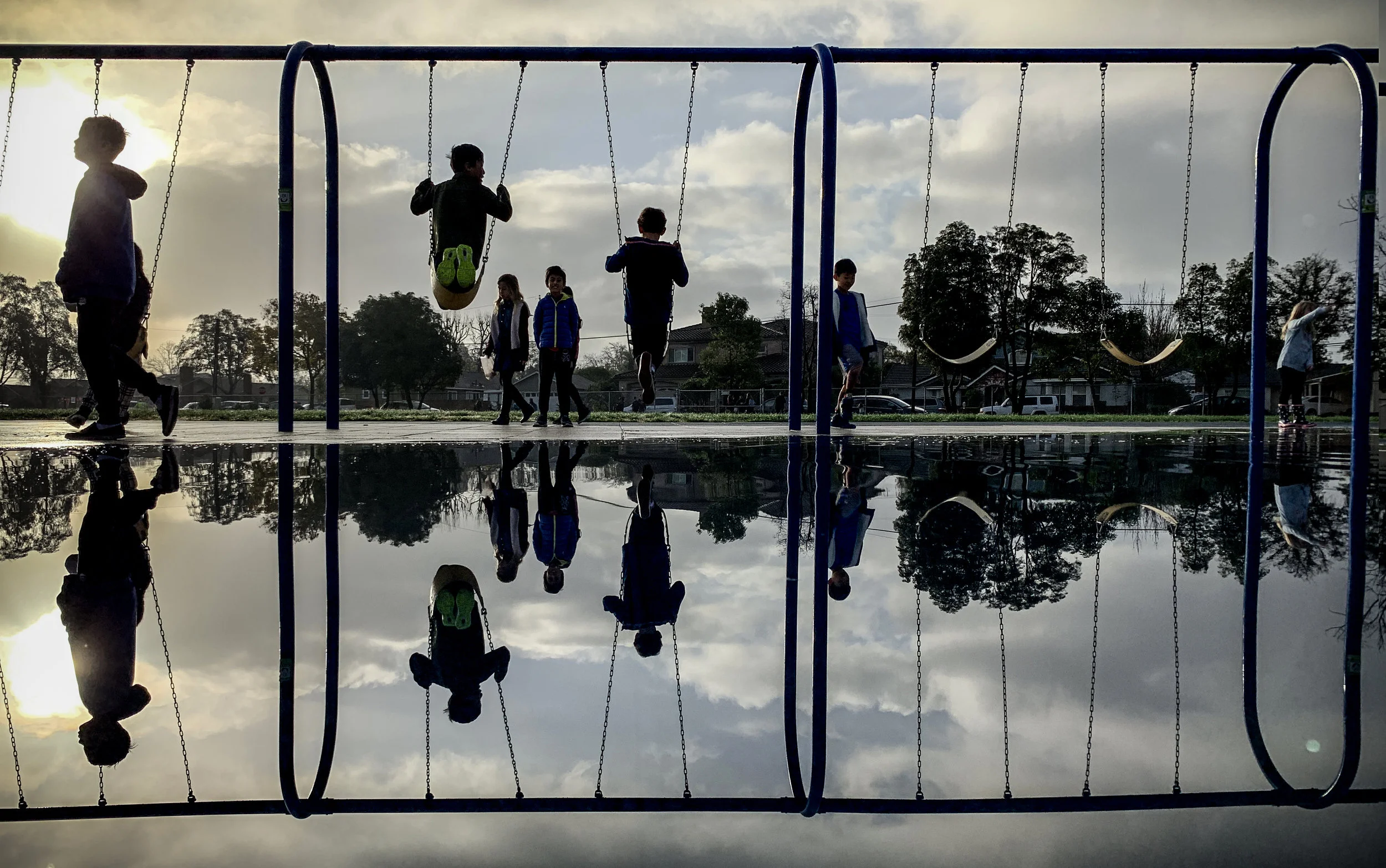 Students at Weaver Elementary School wait for class to start as the play on flooded equipment in Rossmoor, CA, on Friday, Jan 18, 2019.