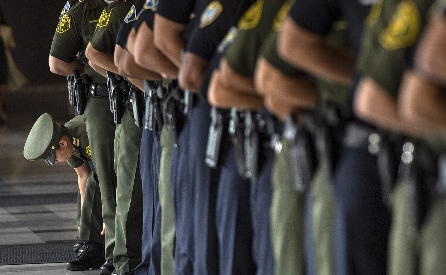 A recruit makes some uniform adjustments before the swearing-in ceremony for incoming Orange County Sheriff Don Barnes in Tustin on Monday, January 7, 2019.