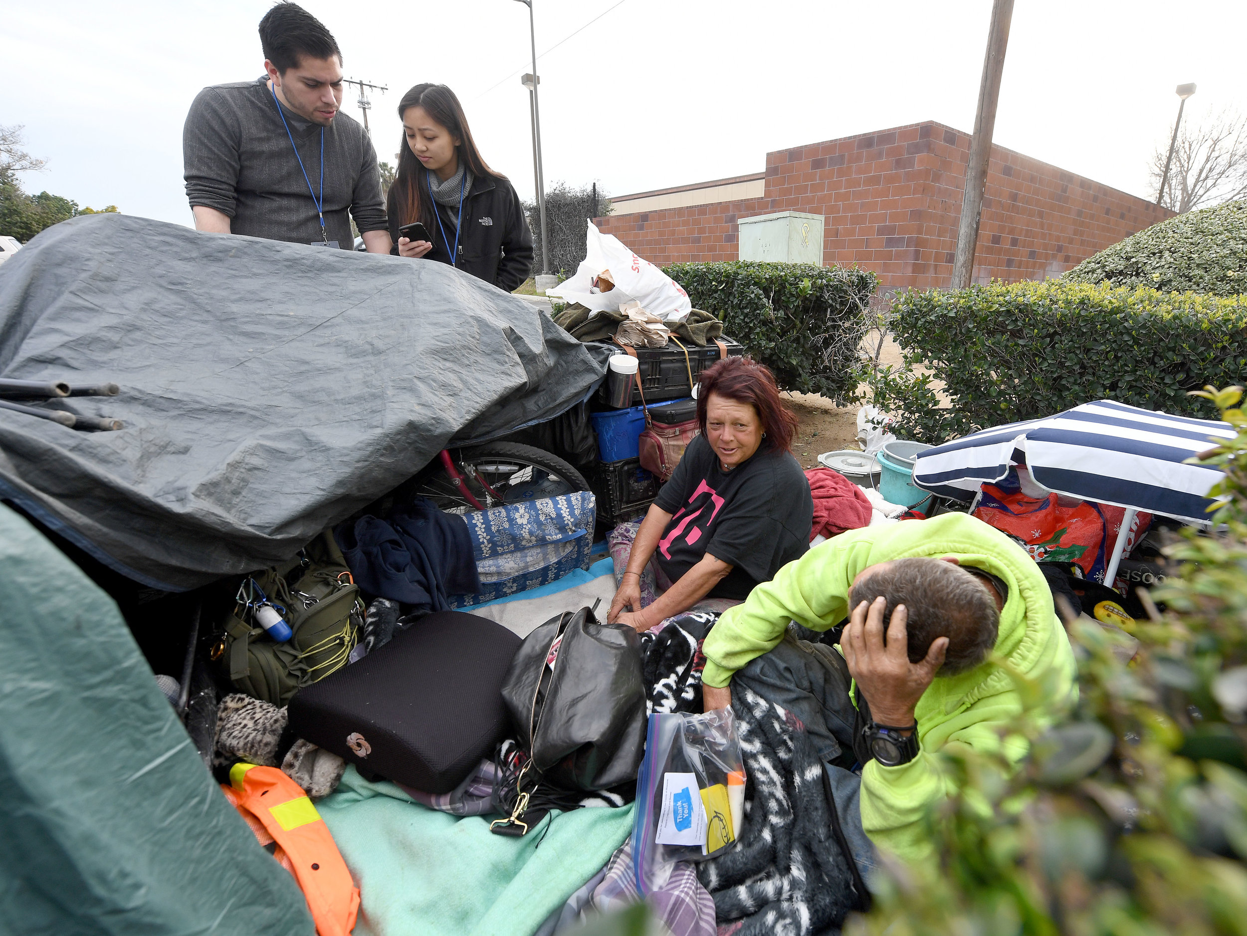  UCR medical students Josue Reynaga and Betty Nguyen, gather information from Annette Alonzo, 53, and William Robinett, 53, from their overnight camp in a parking lot near the intersection of Tyler and Hole streets during the 2019 Point-in-Time Homel