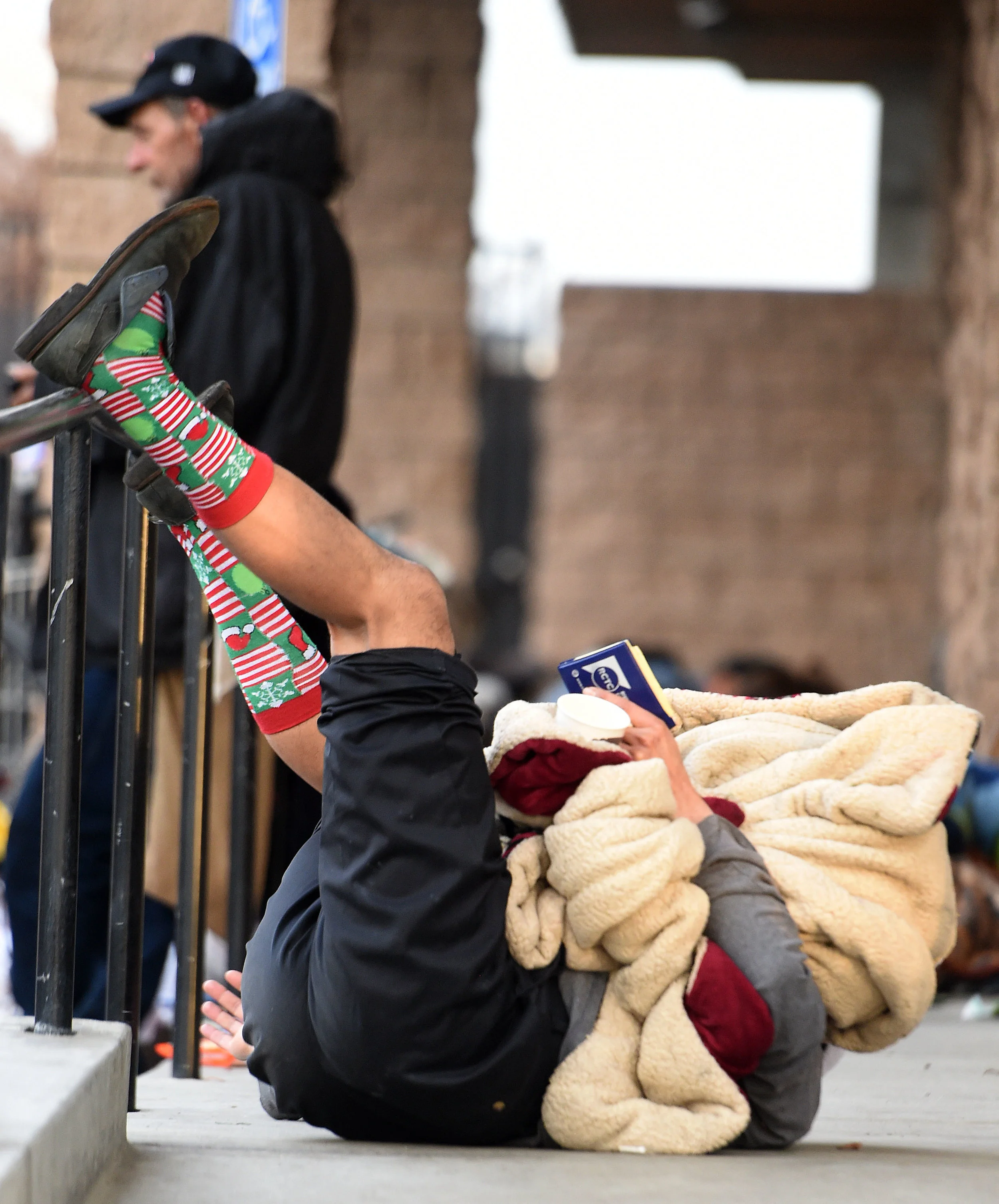  A man rolls around on the groud outside the La Sierra Library during the 2019 Point-in-Time Homeless Count and Survey in Riverside Tuesday morning, January 29, 2019. Over 700 volunteers took part in the county wide count using a specially designed p