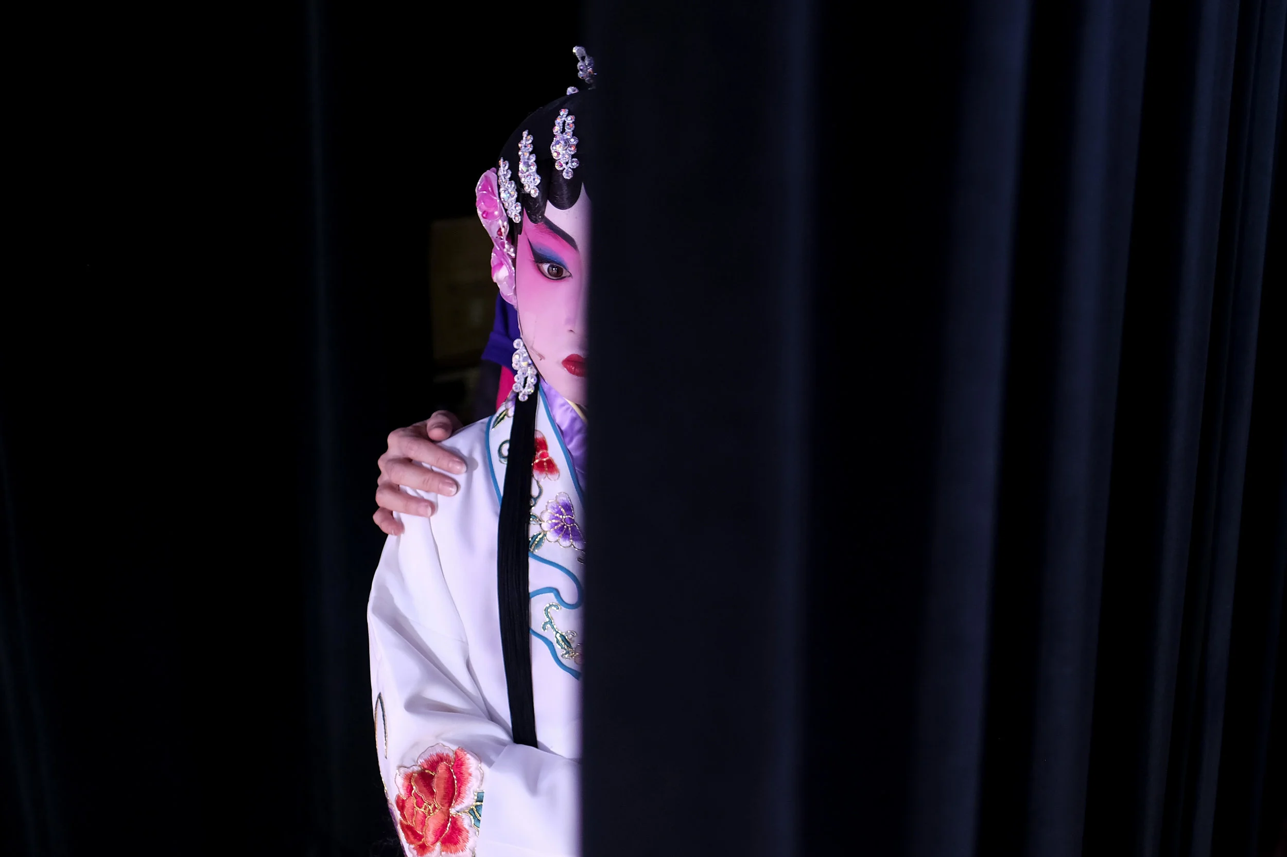  A young artist waits behind the curtain during the Children's Cantonese Opera to celebrate Chinese Lunar New Year in Los Angeles, Jan. 19, 2018. 
