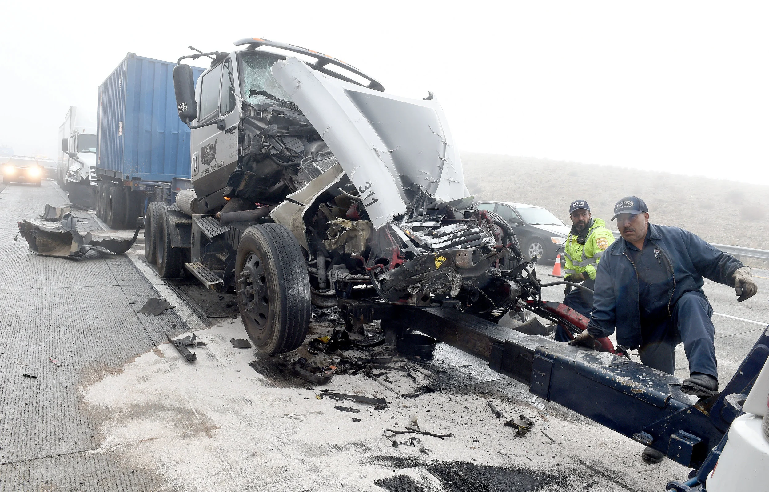  Crews work to clear one of the crashed big rig trucks involved in a major pile up on the southbound I-15 Freeway in the Cajon Pass Wednesday morning. The southbound I-15 Freeway was shut down in the Cajon Pass Wednesday, January 16, 2019 for several