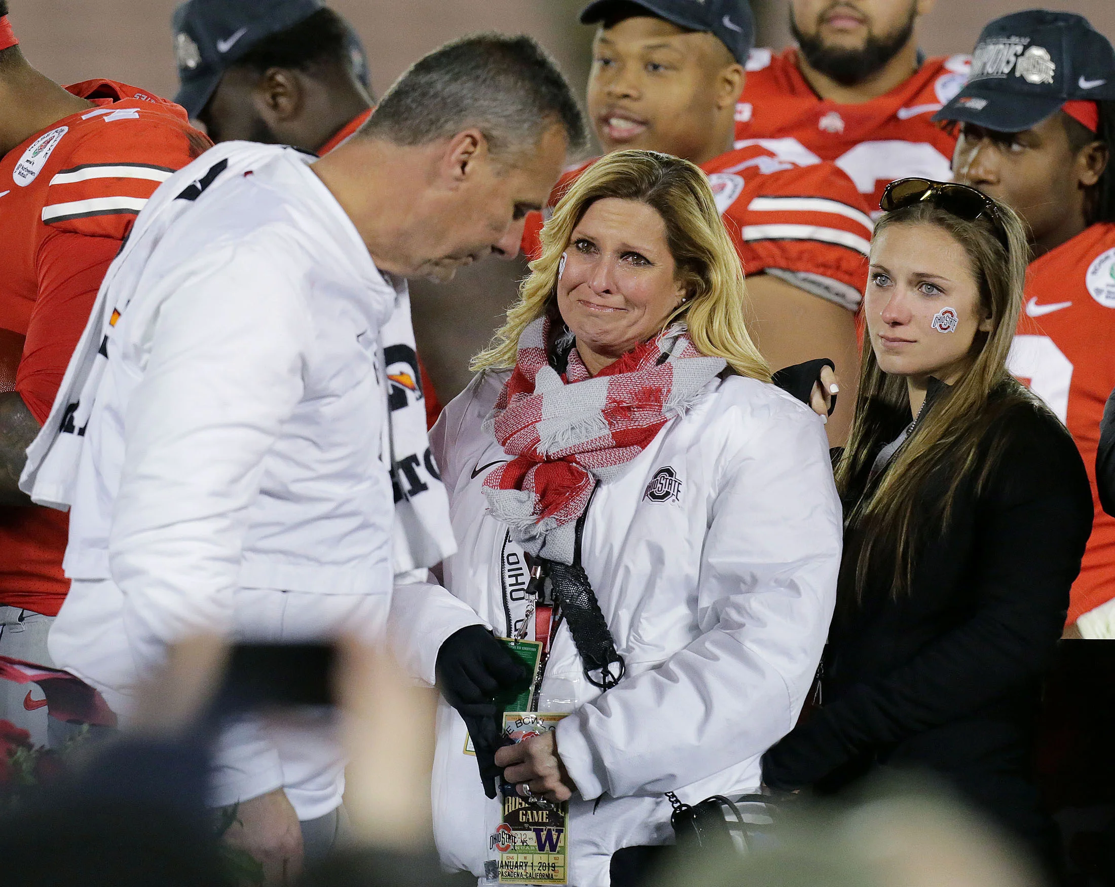 Ohio State Buckeyes head coach Urban Meyer lowers his head as he walks off stage after winning his last game as head coach at Ohio State while his wife, Shelley Mather Meyer and daughter cry as they watch him at the end of the 105th Rose Bowl game in Pasadena on Tuesday, January 1, 2019.