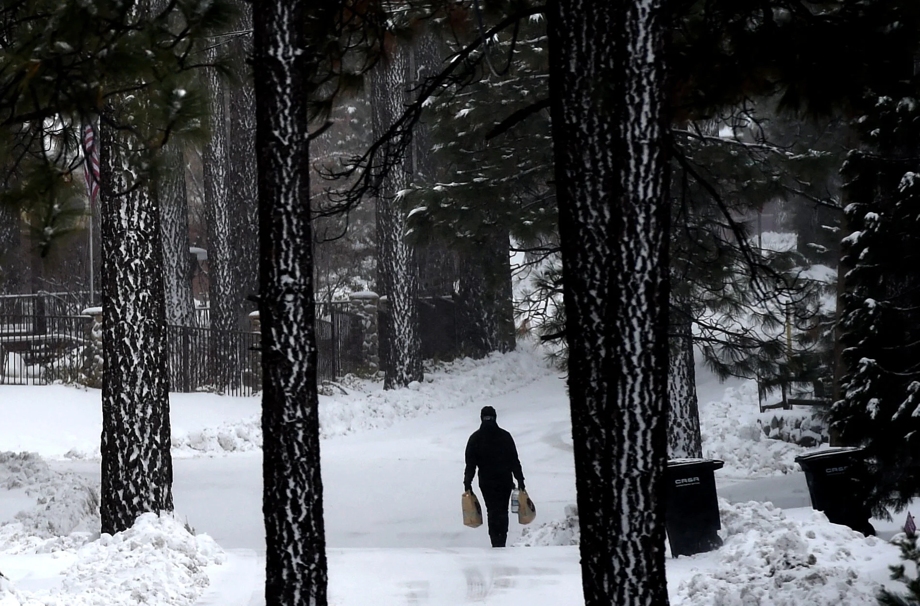  A man carries his groceries home in the snow as the afternoon temperature drops to 25 degrees in Wrightwood on Tuesday, February 5, 2019. Overnight snow could drop to the 2,500ft level tonight and a winter storm warning remains in effect until 4am W