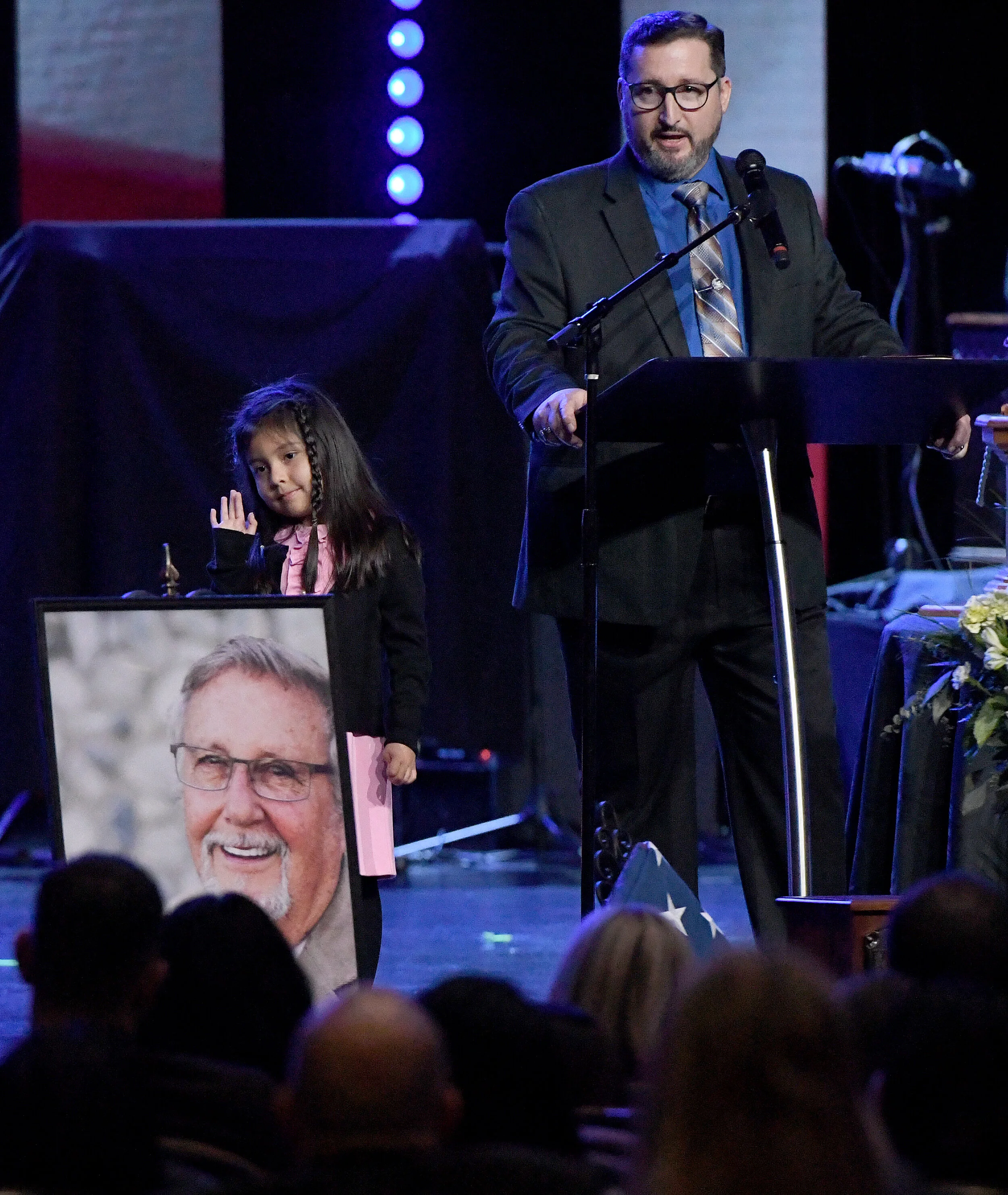  William Alexander, the son of the late William Alexander, speaks about his father, while the late mayor's granddaughter Kailee waves to family members during his memorial service at Abundant Living Family Church in Rancho Cucamonga Saturday morning 