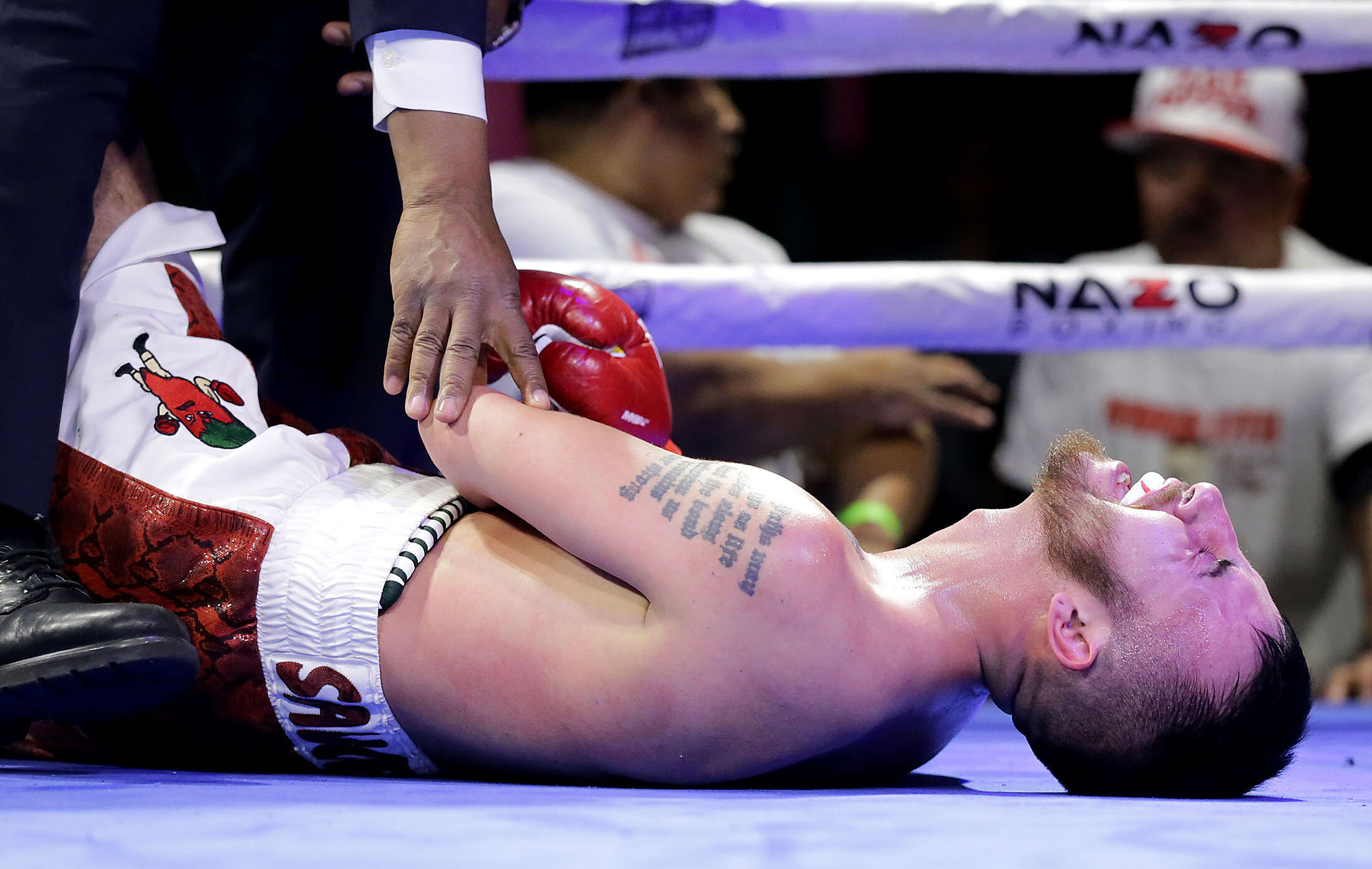 Carlos Saucedo, grimaces in pain on the mat after breaking his left wrist with a body shot blocked by Misael Chacon in the second round of their super featherweight bout at Florentine Gardens in Hollywood on Saturday, February 16, 2019. PUBLISHED Fe