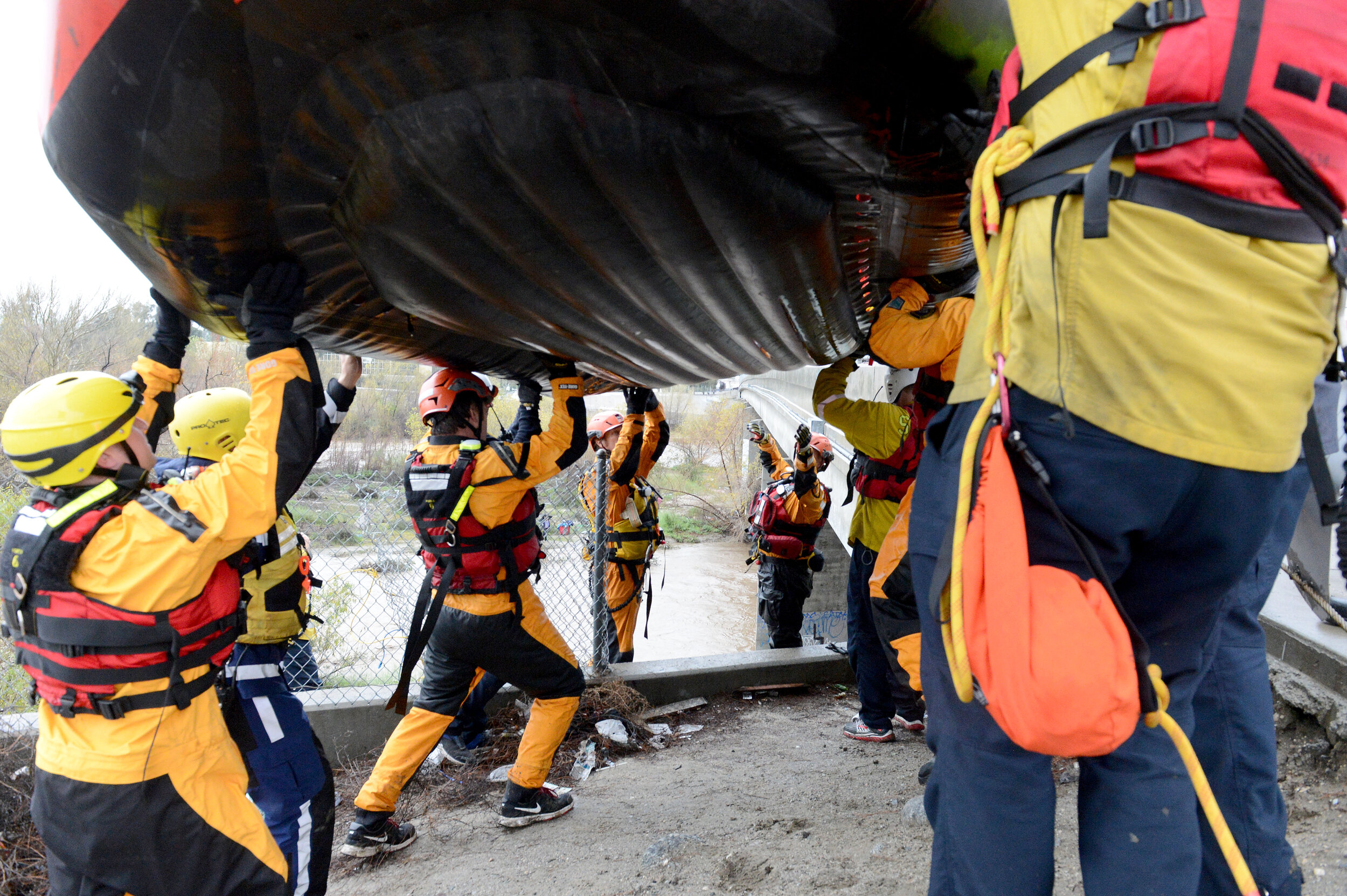  A San Bernardino County Fire swift rescue team prepares to put a raft in the water for a rescue in the Santa Ana River bed Thursday. A San Bernardino County Fire swift rescue team rescued 8 individuals stranded on an island in the rain swollen Santa